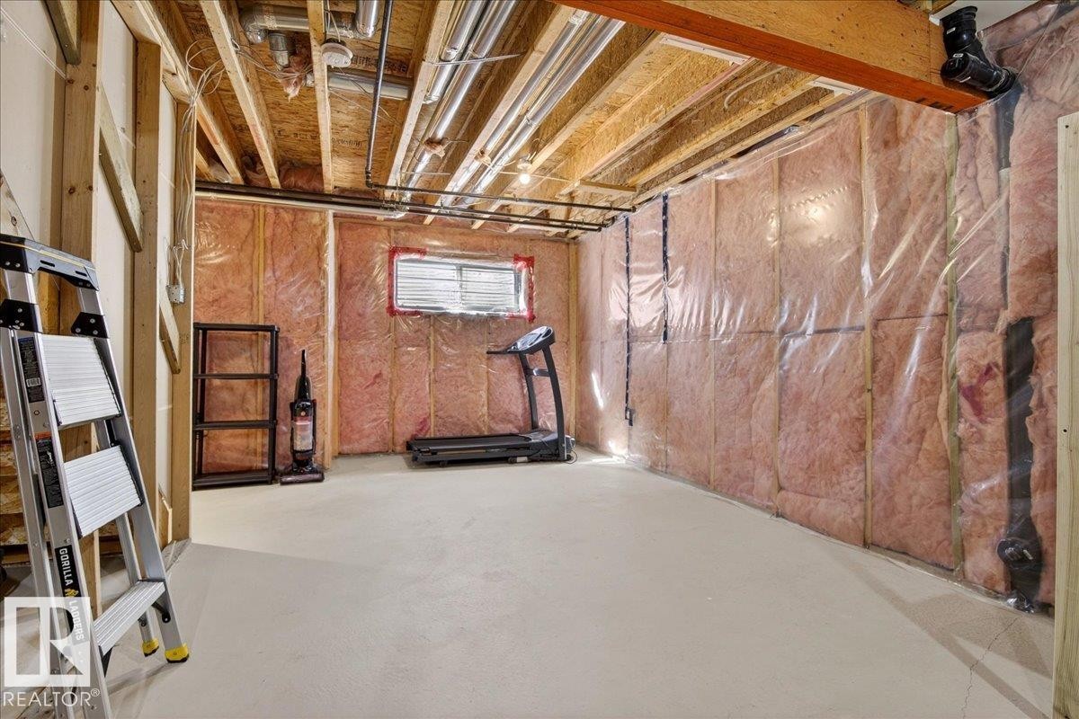 Unfinished basement area featuring exposed ceiling joists, visible HVAC ductwork, and insulation-lined walls with vapor barrier - 18 6032 38 Avenue, Edmonton, AB - Indoor Photo Showing Basement