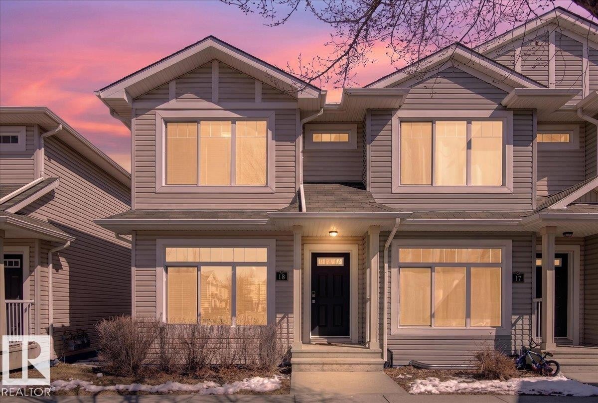 Contemporary two-story exterior with light gray siding, prominent gables, a dark front door, white trim, and multiple large windows - 18 6032 38 Avenue, Edmonton, AB - Outdoor With Facade