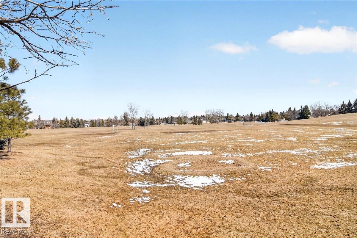 Expansive open field with scattered evergreen trees and distant residential structures - 18 6032 38 Avenue, Edmonton, AB - Outdoor With View