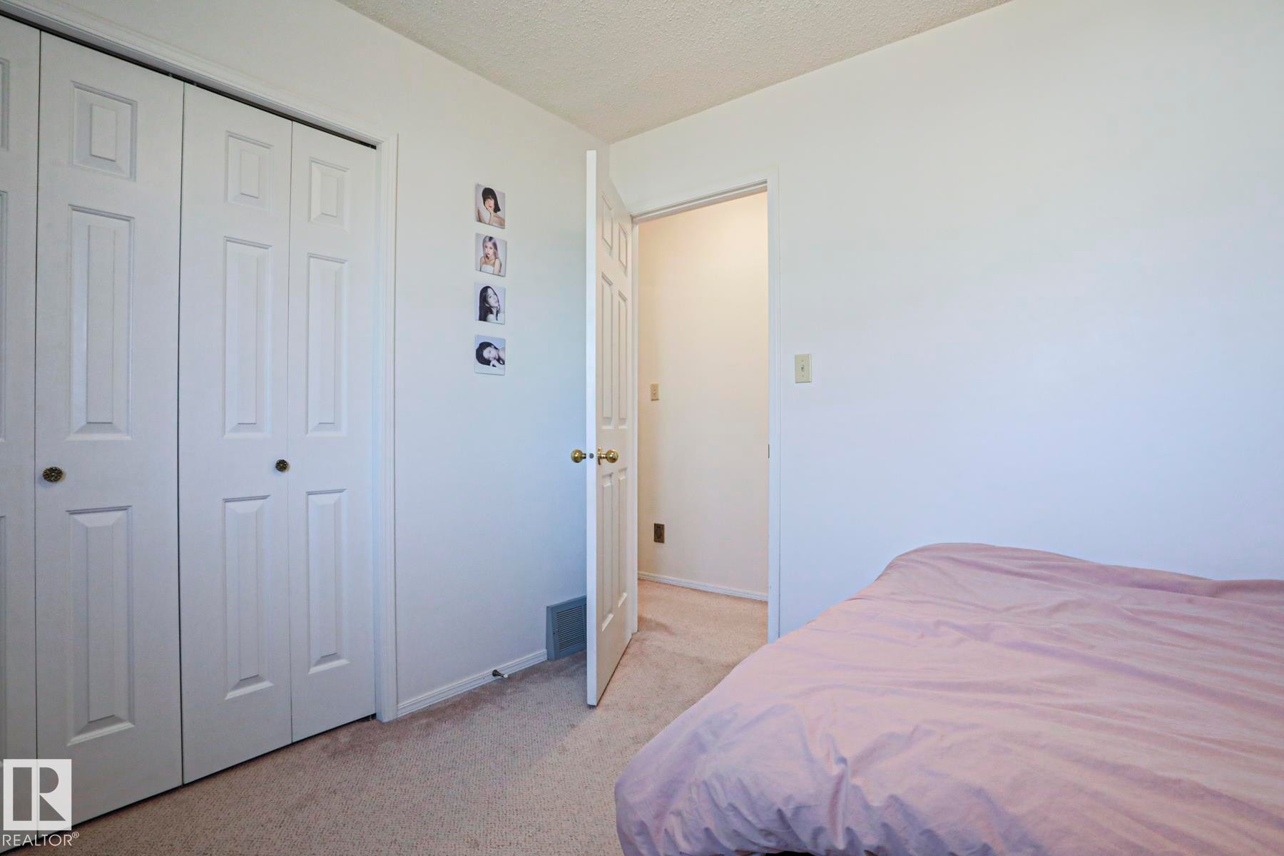 Room featuring neutral tone walls, textured ceiling, and carpeted flooring - 2433 89 Street, Edmonton, AB - Indoor Photo Showing Bedroom