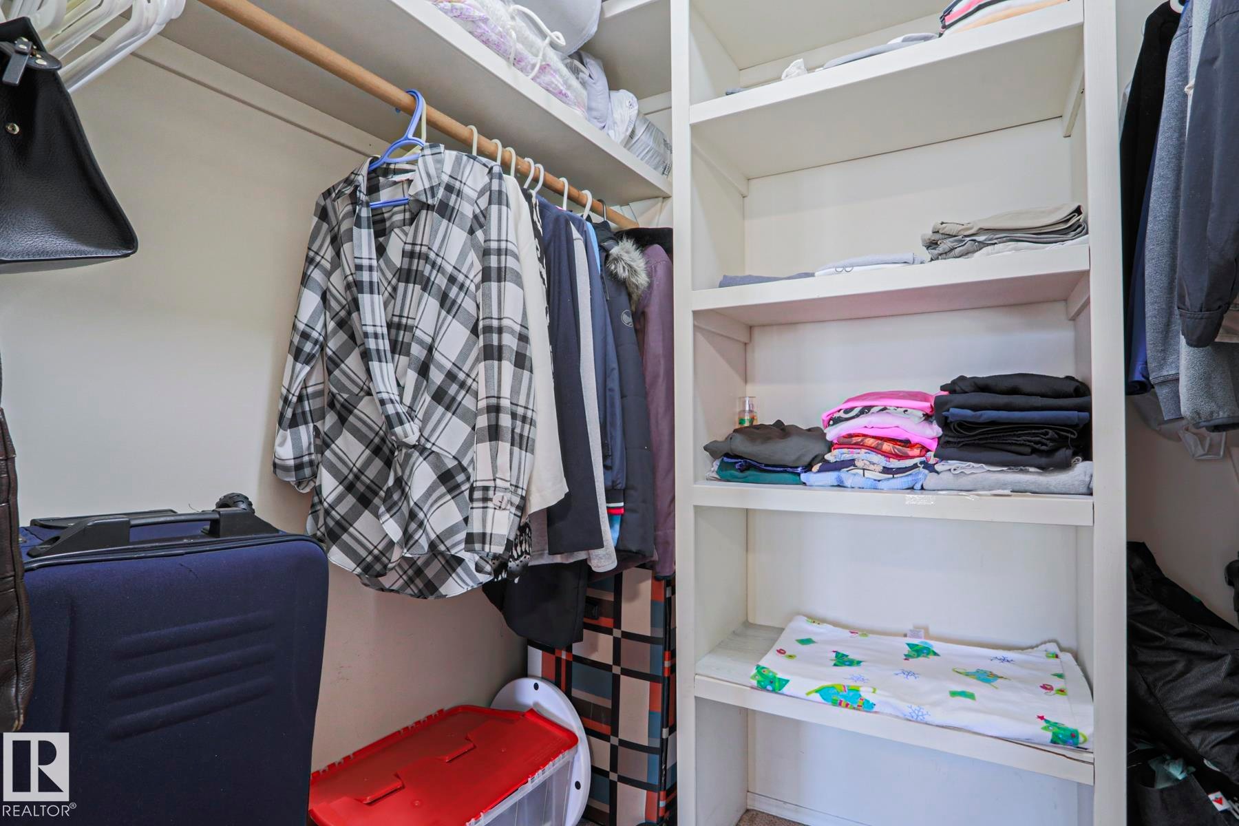 Integrated closet storage system featuring hanging rods, built-in shelving, and a neutral color palette - 2433 89 Street, Edmonton, AB - Indoor With Storage