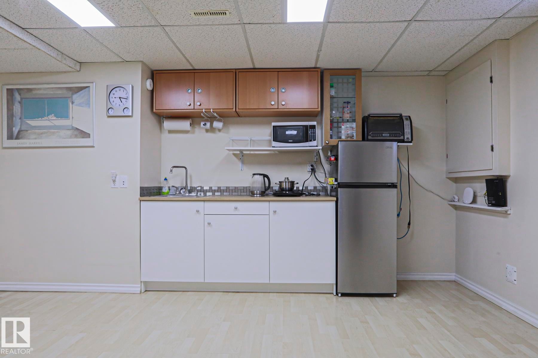 Compact kitchenette featuring wood-finish flooring and a drop ceiling - 2433 89 Street, Edmonton, AB - Indoor Photo Showing Other Room