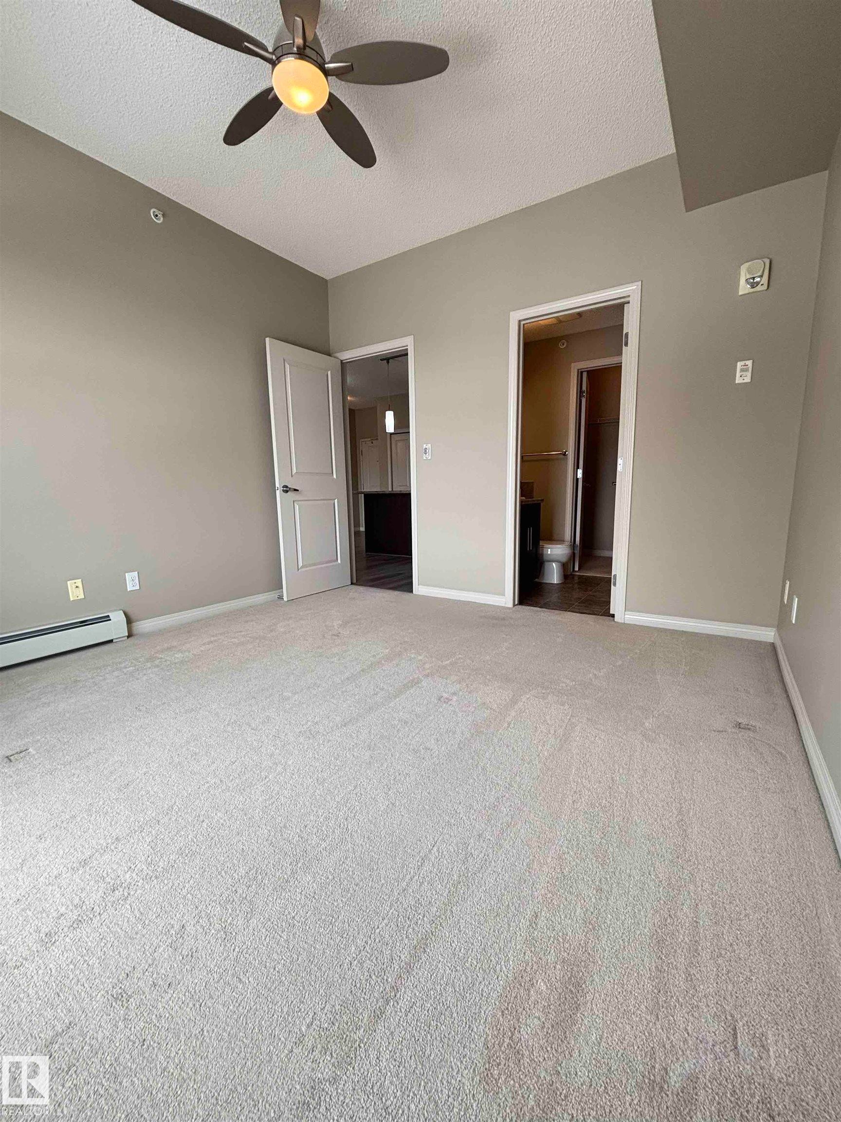 Neutral tone wall paint with light-colored carpeting - 408 111 Ambelside Drive Sw, Edmonton, AB - Indoor Photo Showing Other Room