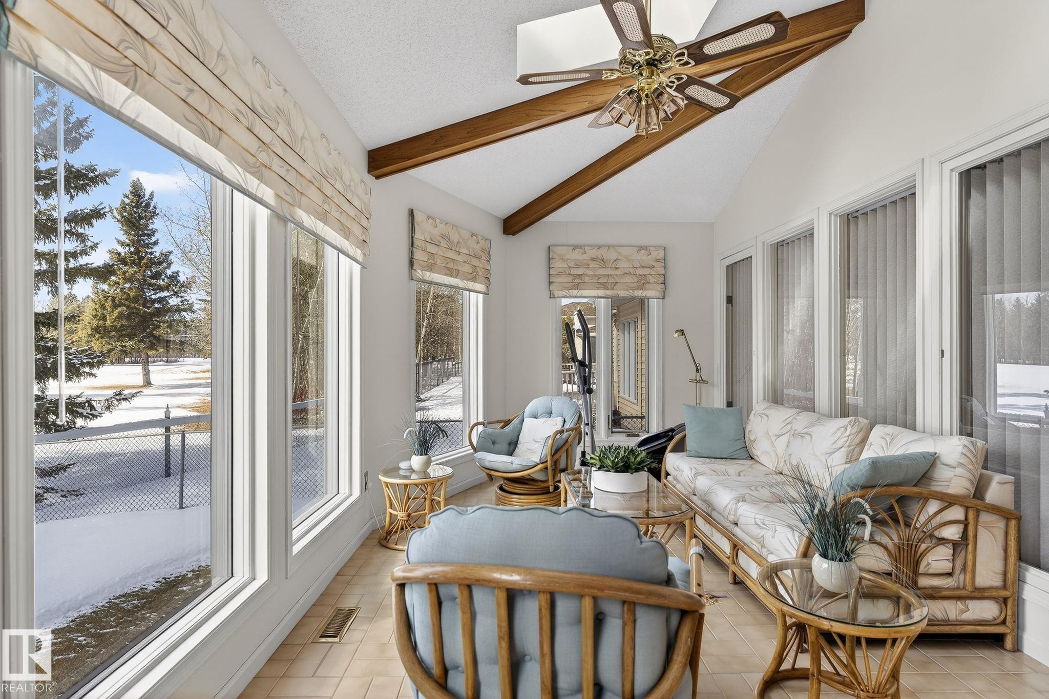 Sunroom featuring a vaulted ceiling with exposed wood beams, a ceiling fan, and extensive window walls - 848 Wheeler Road W, Edmonton, AB - Indoor