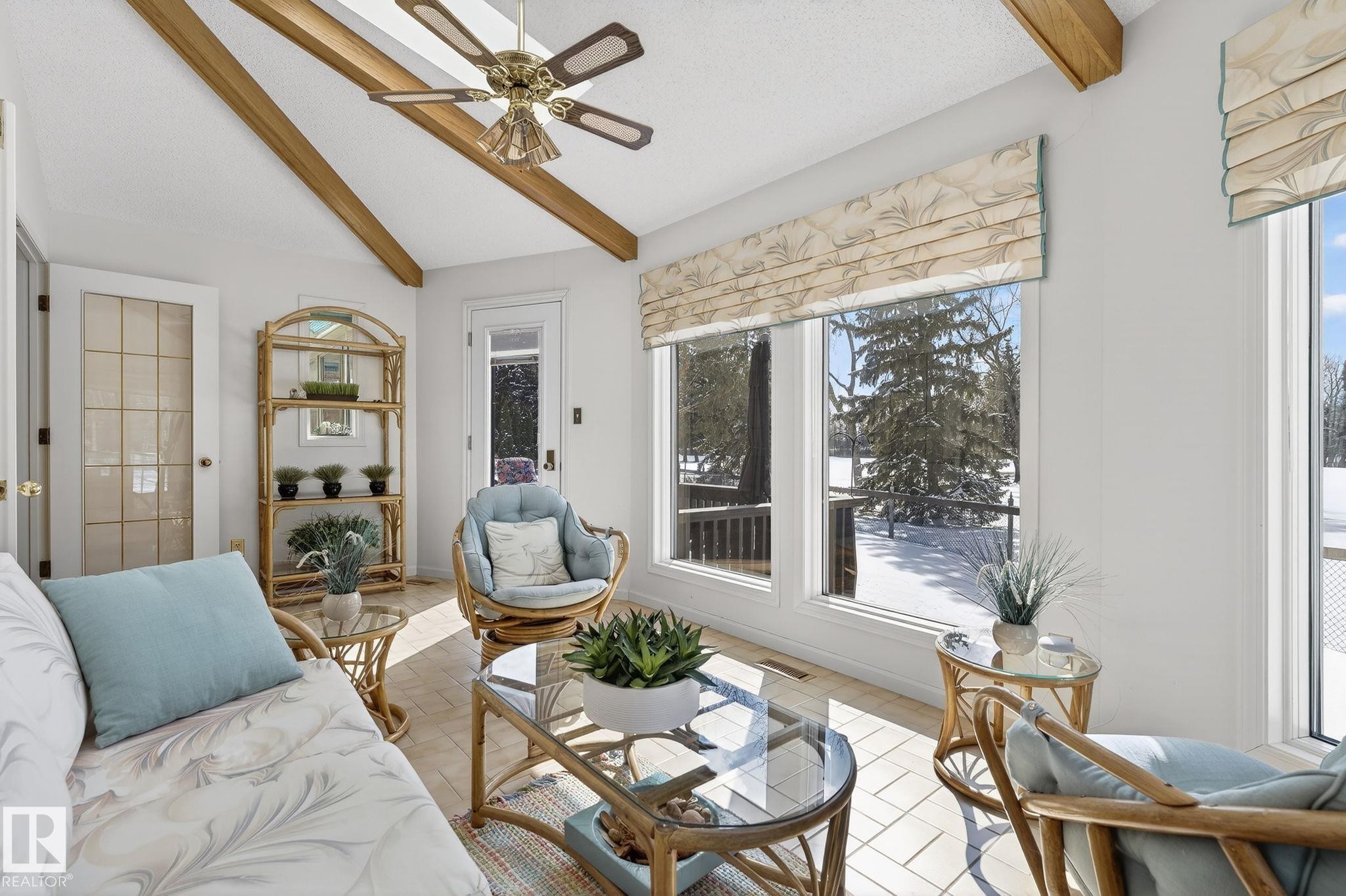 Sunroom featuring vaulted ceilings with exposed wood beams and a brass-finish ceiling fan - 848 Wheeler Road W, Edmonton, AB - Indoor Photo Showing Living Room