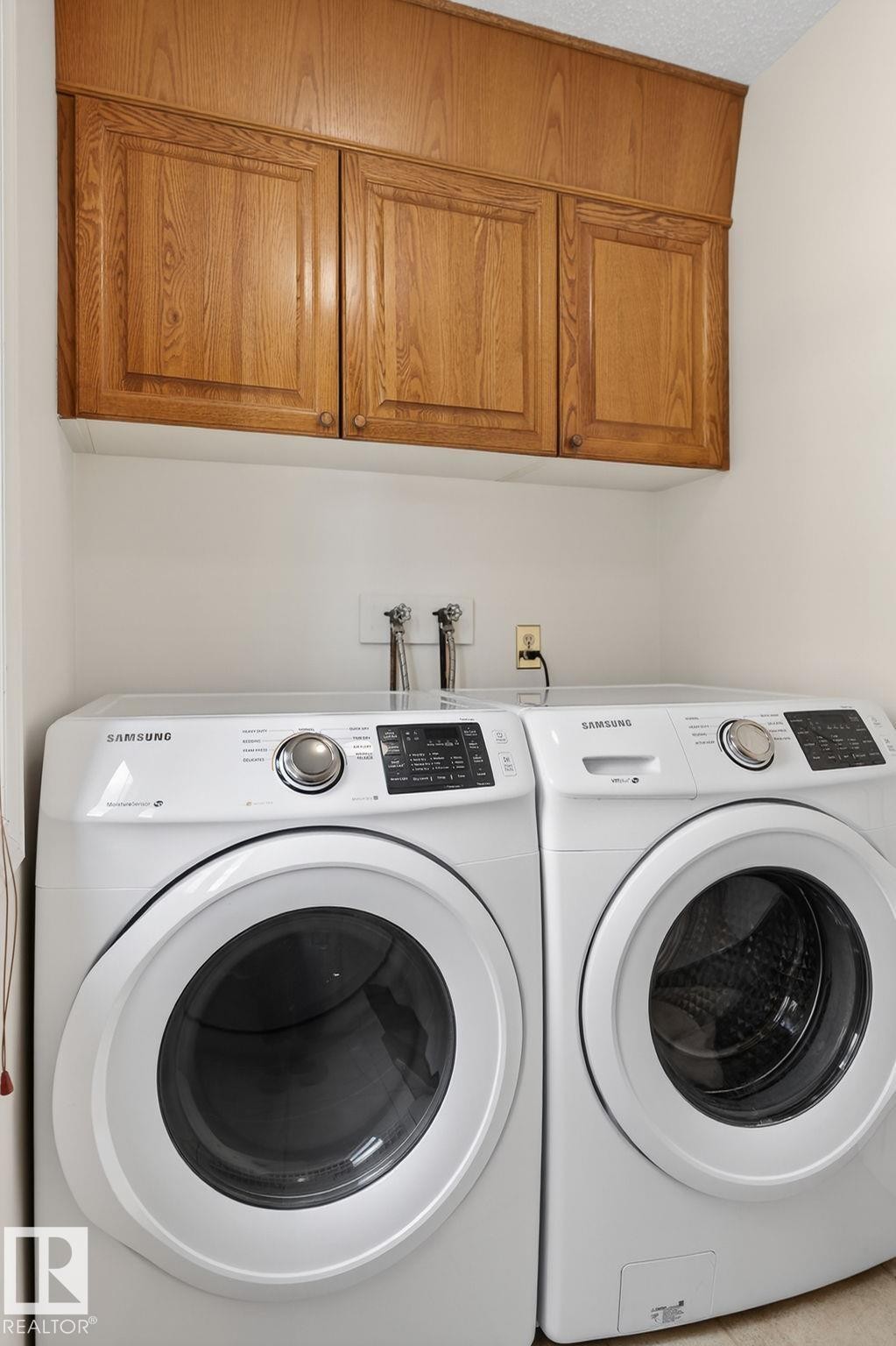 Laundry area featuring wood-finish cabinetry and white walls - 848 Wheeler Road W, Edmonton, AB - Indoor Photo Showing Laundry Room
