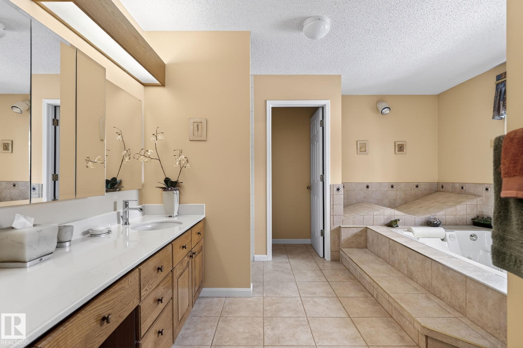 Bathroom featuring a dual vanity with a white countertop and wood-finish cabinetry - 848 Wheeler Road W, Edmonton, AB - Indoor Photo Showing Bathroom