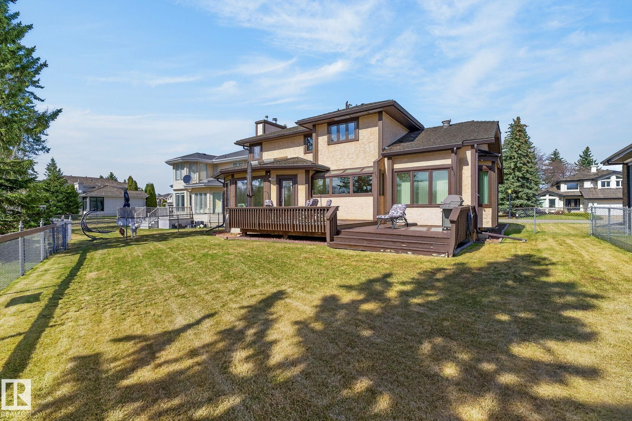Rear exterior with a multi-level wood deck and stucco finish - 848 Wheeler Road W, Edmonton, AB - Outdoor