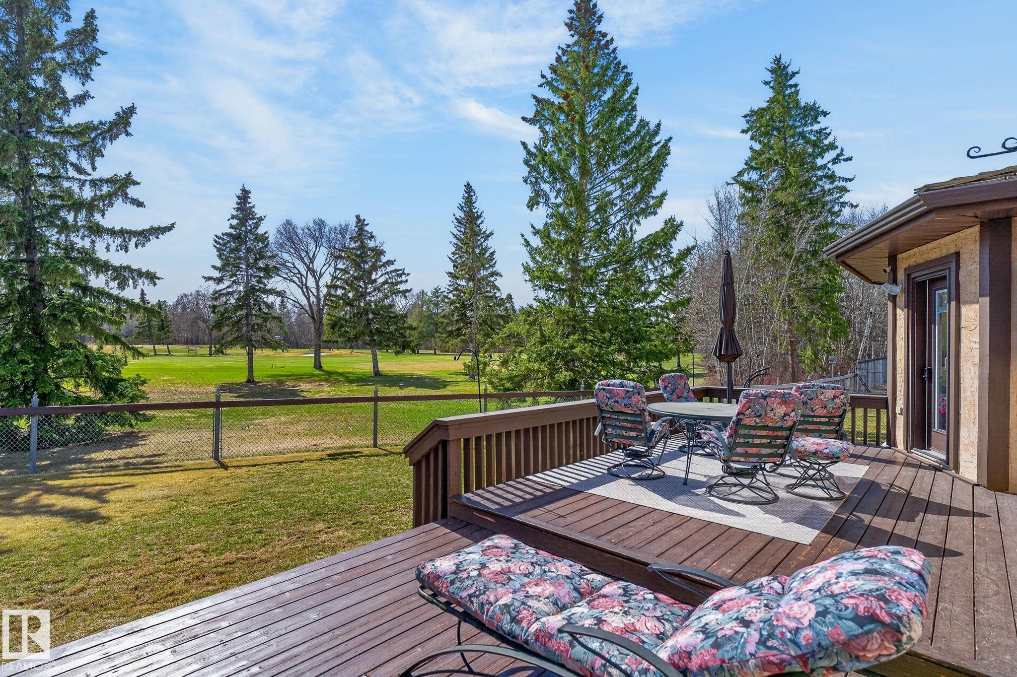 Expansive wood-finish decking featuring a dining area and direct exterior access - 848 Wheeler Road W, Edmonton, AB - Outdoor With Deck Patio Veranda