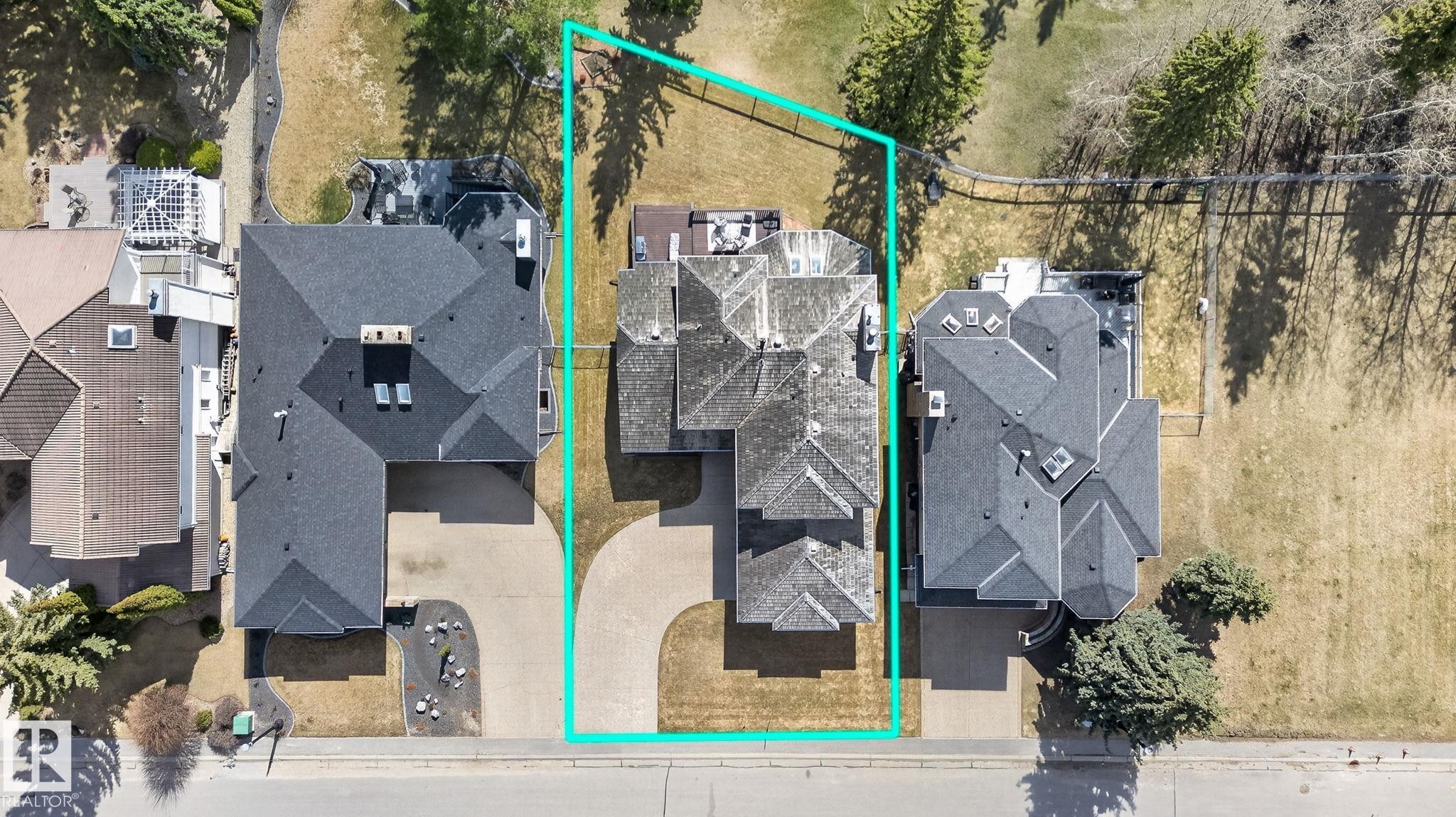 Aerial property overview featuring a multi-gabled roofline, concrete driveway, and a fenced perimeter - 848 Wheeler Road W, Edmonton, AB - Outdoor