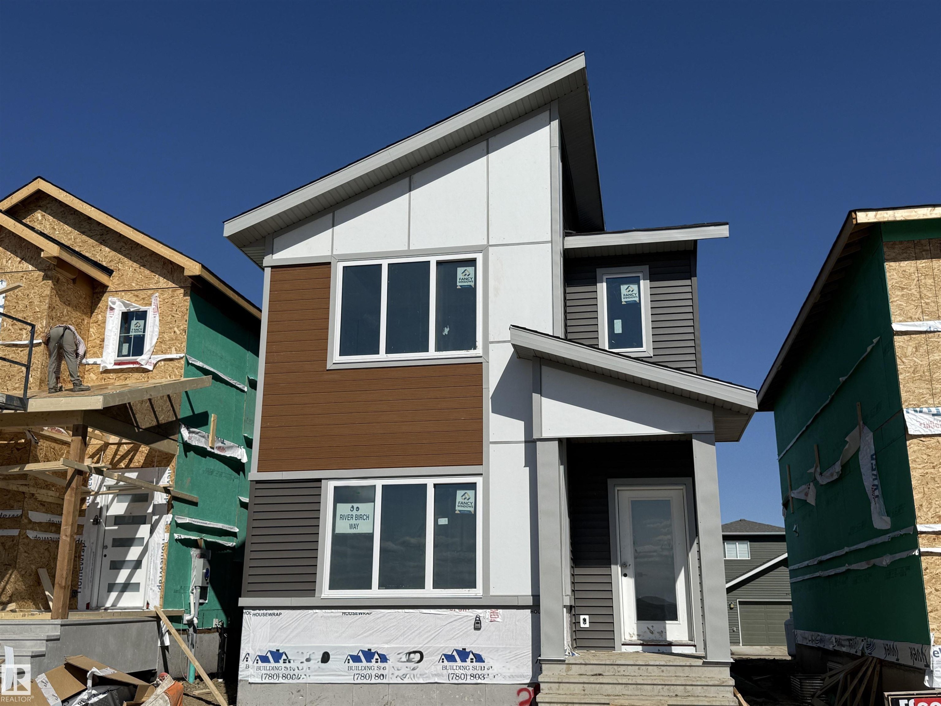 Modern two-story residence featuring a multi-textured facade with brown horizontal siding, gray horizontal siding, and white paneling - 45 River Birch, St. Albert, AB - Outdoor