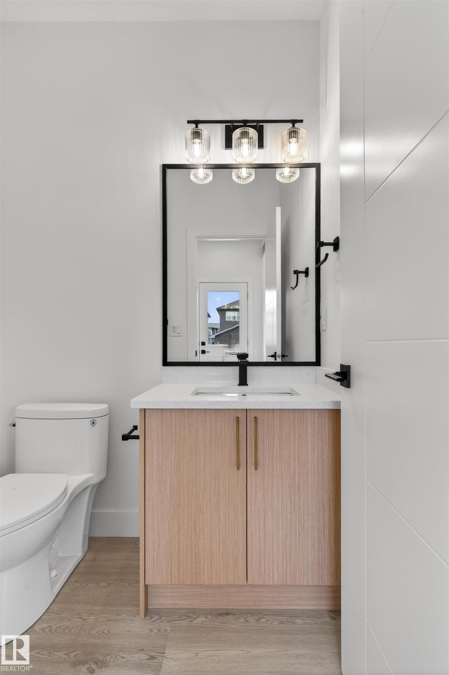 Bathroom vanity with light wood-finish cabinetry, a white countertop, and an undermount sink - 45 River Birch, St. Albert, AB - Indoor Photo Showing Bathroom