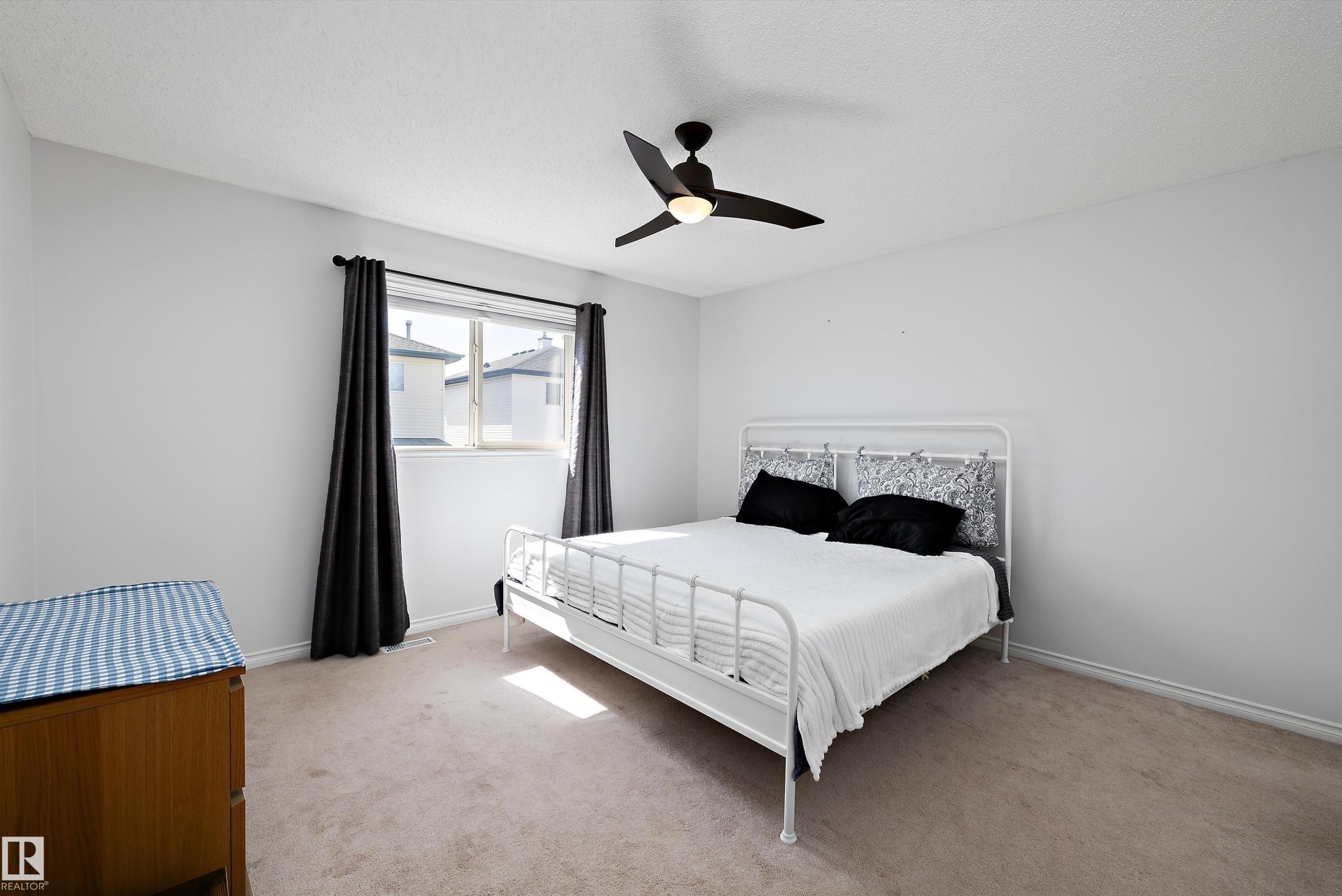 Bright room featuring a ceiling fan, light-colored walls, and neutral carpeting - 1811 37 Avenue, Edmonton, AB - Indoor Photo Showing Bedroom