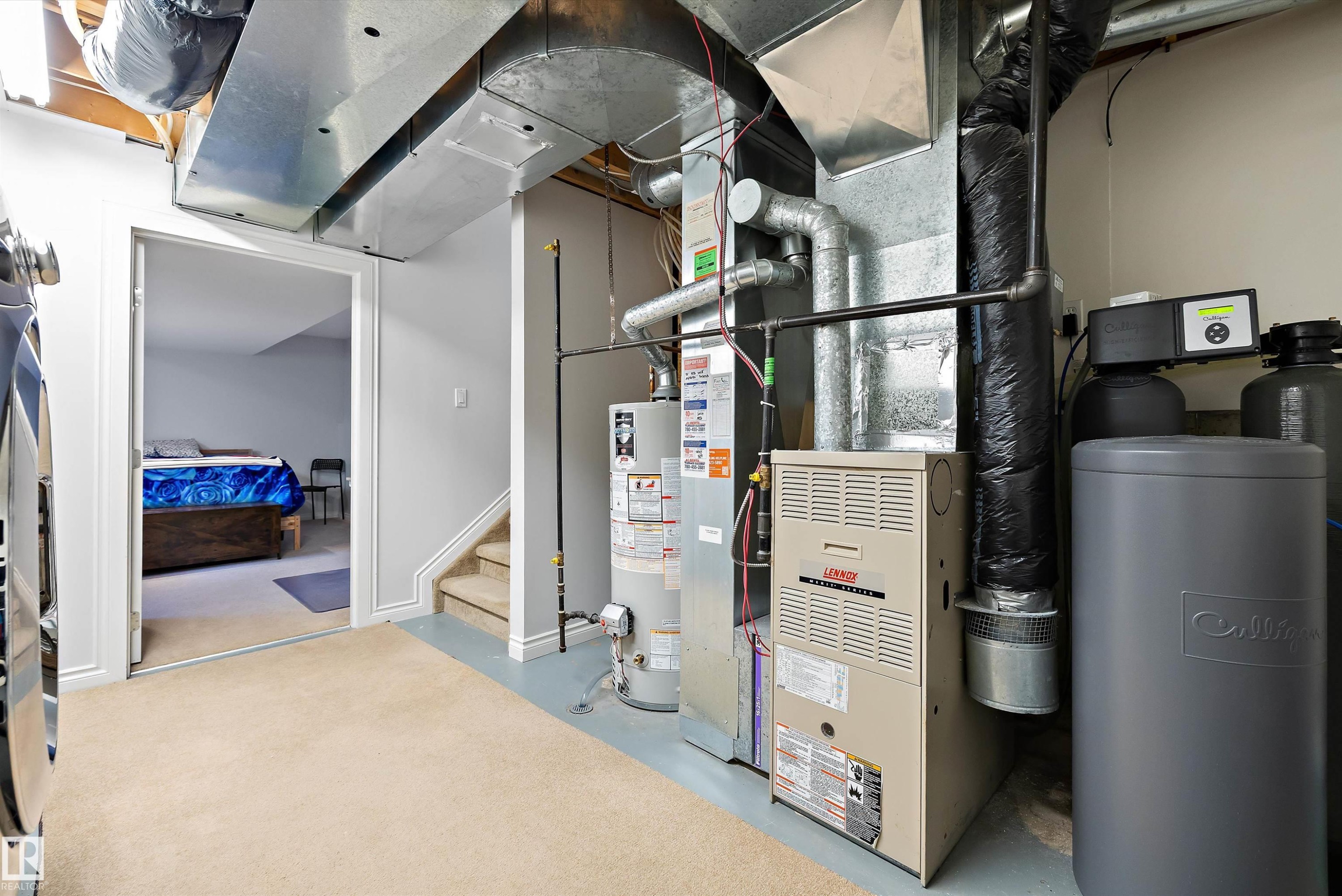 Dedicated utility space featuring a furnace, water heater, water softener system, and exposed ductwork - 1811 37 Avenue, Edmonton, AB - Indoor Photo Showing Basement