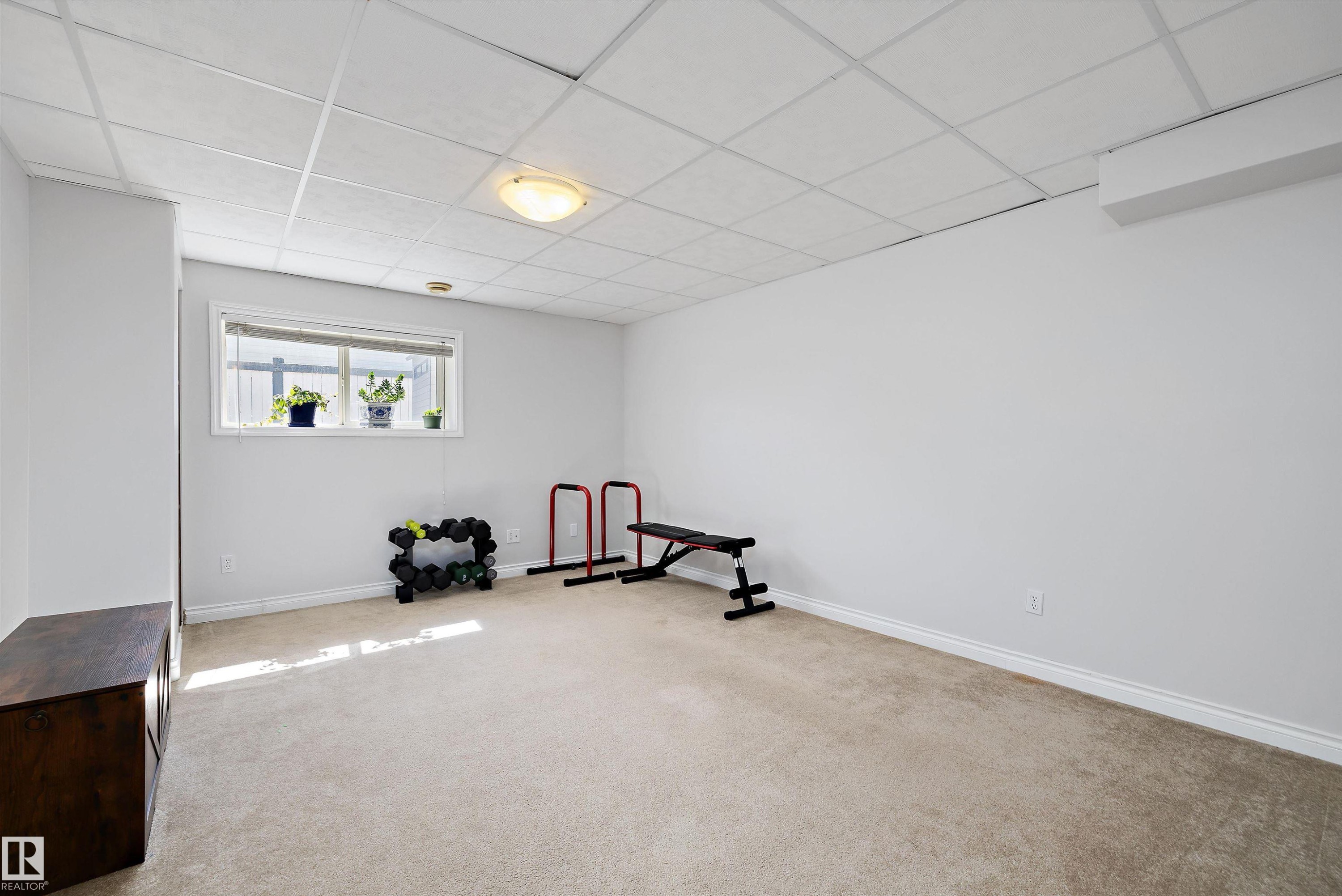 Finished basement space featuring light carpet, neutral walls, and a drop ceiling with recessed lighting - 1811 37 Avenue, Edmonton, AB - Indoor