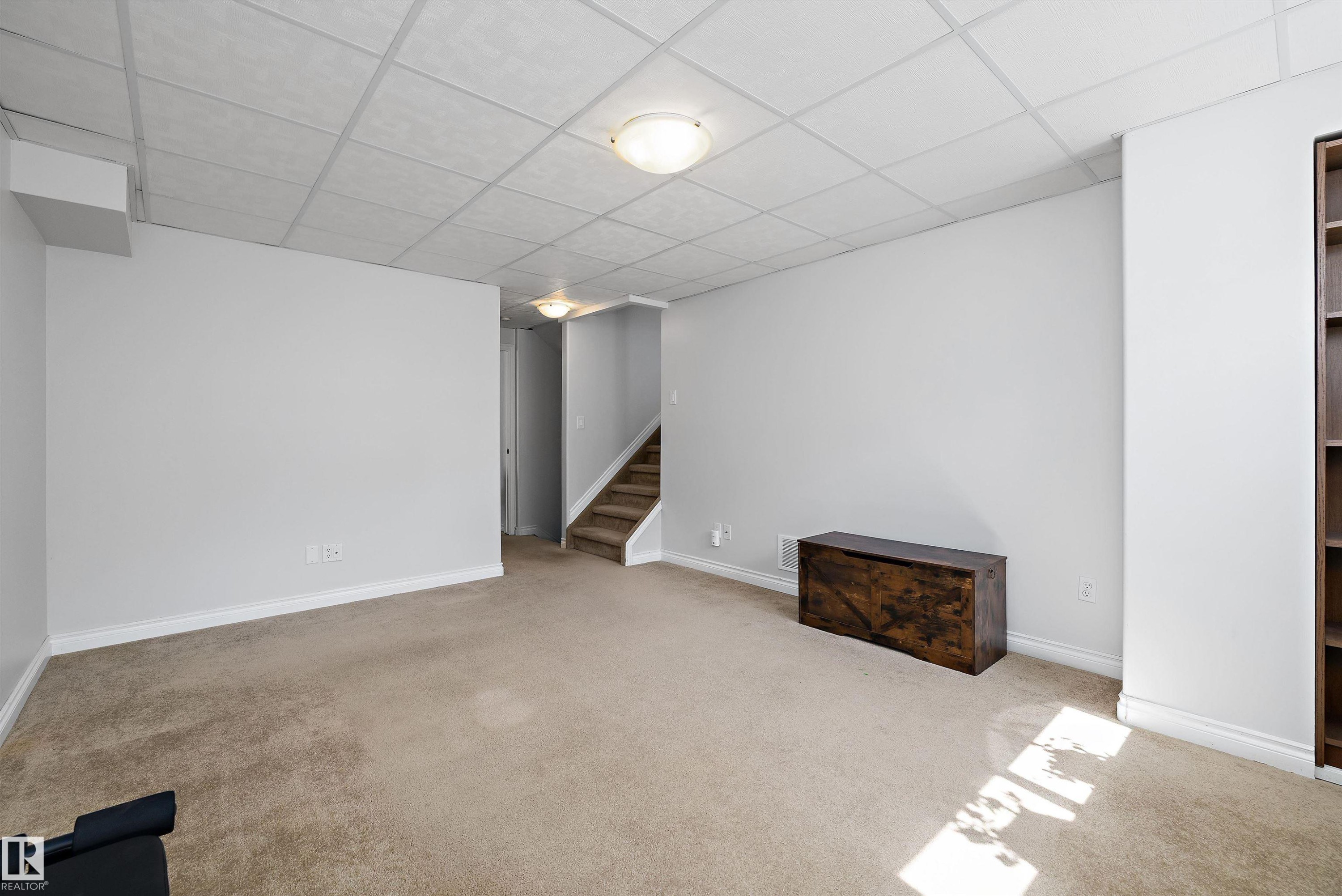 Carpeted lower level with light gray walls and white trim - 1811 37 Avenue, Edmonton, AB - Indoor Photo Showing Other Room
