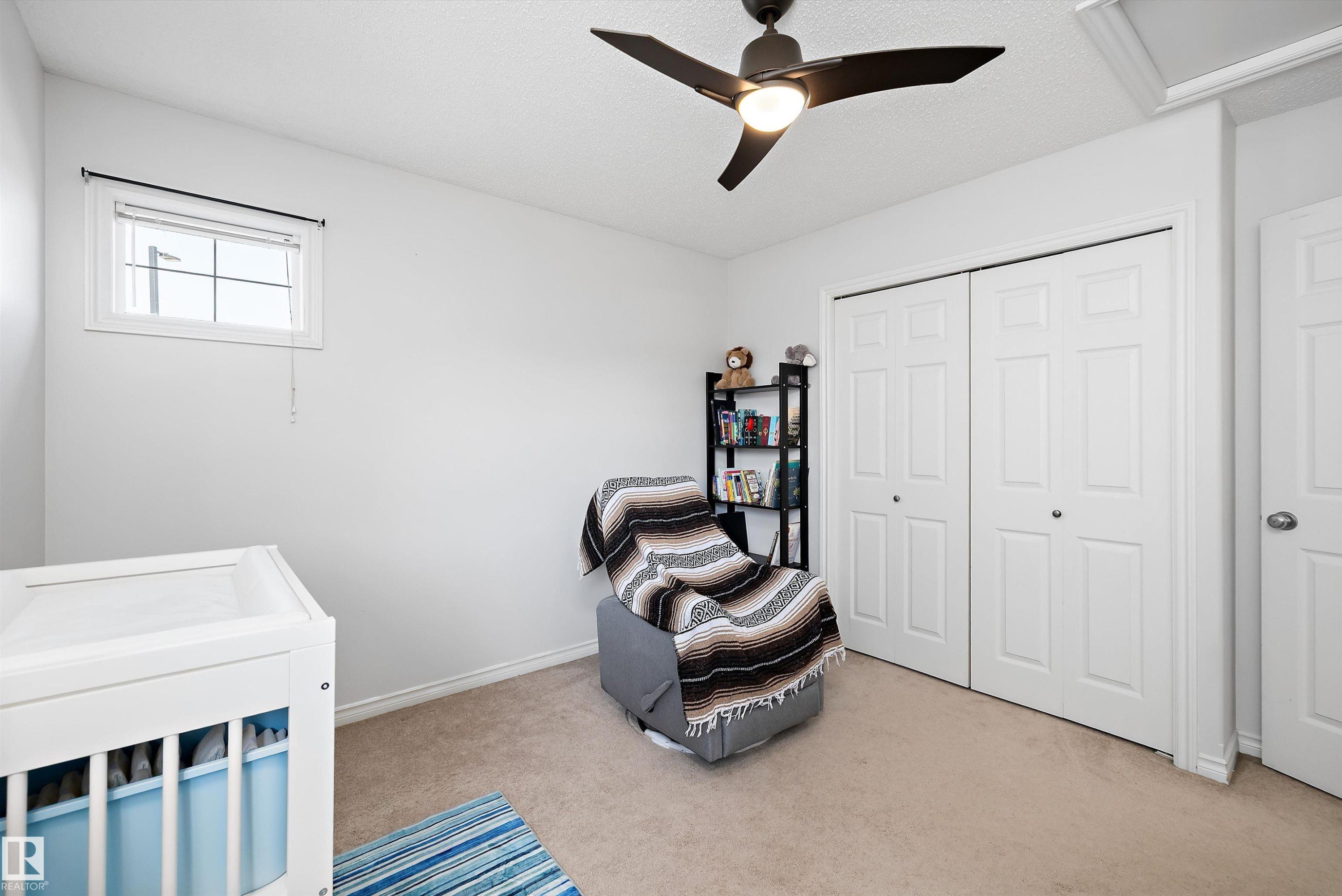 Room with light beige carpet flooring, a multi-pane window, and a ceiling fan with integrated lighting - 1811 37 Avenue, Edmonton, AB - Indoor