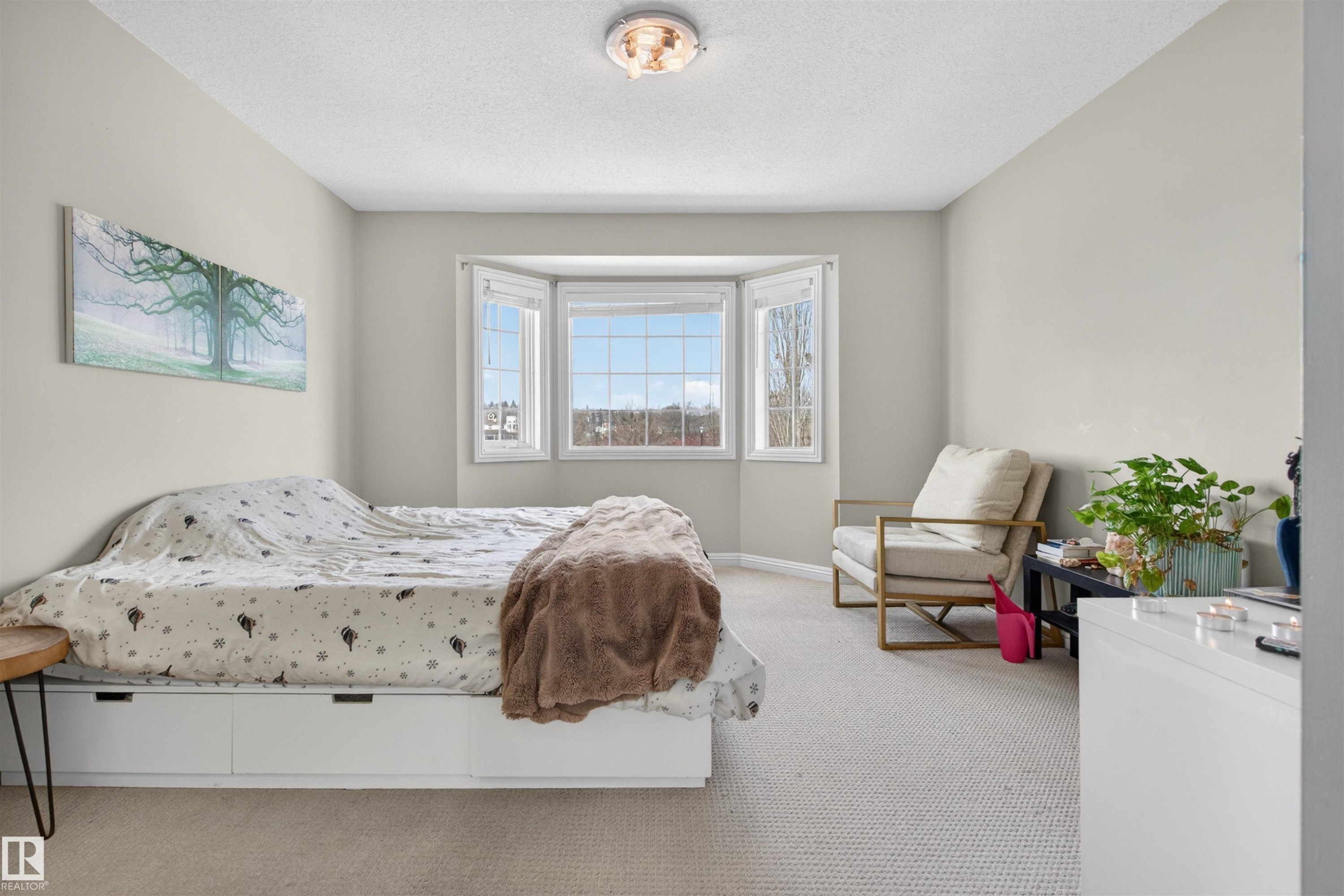 This inviting room features a prominent bay window, carpeted flooring, and a ceiling light fixture - 2 Sturgeon Road, St. Albert, AB - Indoor Photo Showing Bedroom