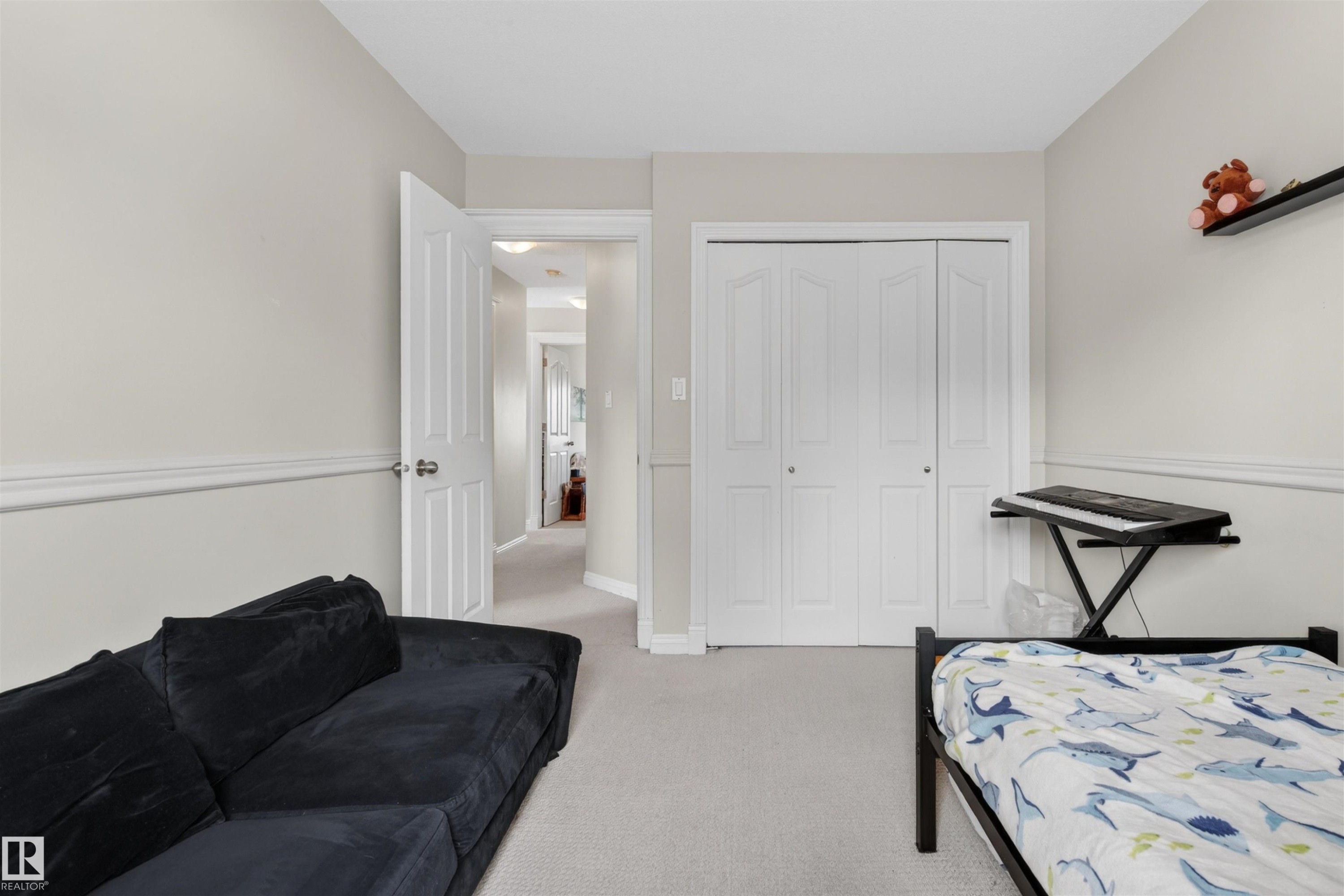 This room features light-colored walls with white trim, wall-to-wall carpeting, and a white bi-fold closet - 2 Sturgeon Road, St. Albert, AB - Indoor Photo Showing Bedroom