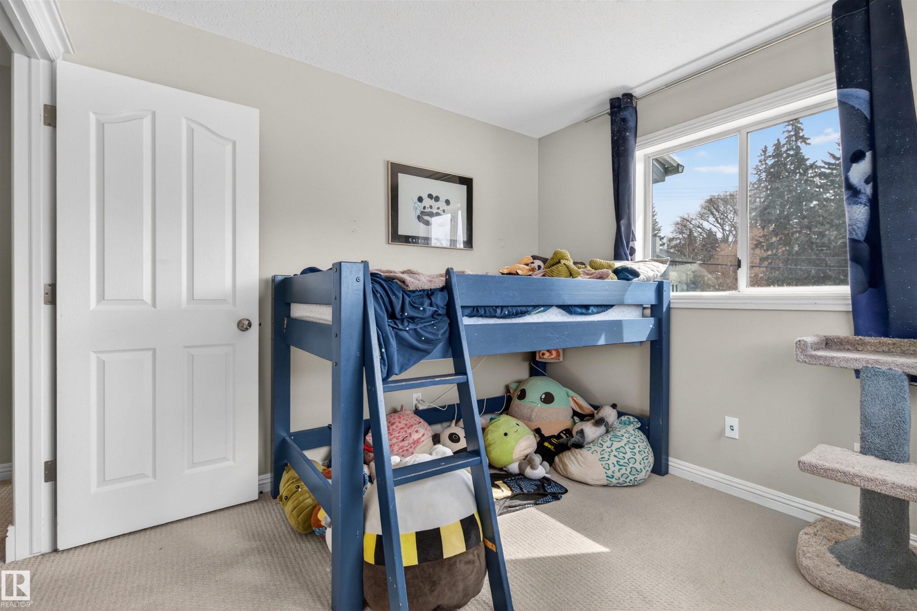 The room features light-colored walls and carpeting, a white paneled door, and a window with white trim - 2 Sturgeon Road, St. Albert, AB - Indoor Photo Showing Bedroom