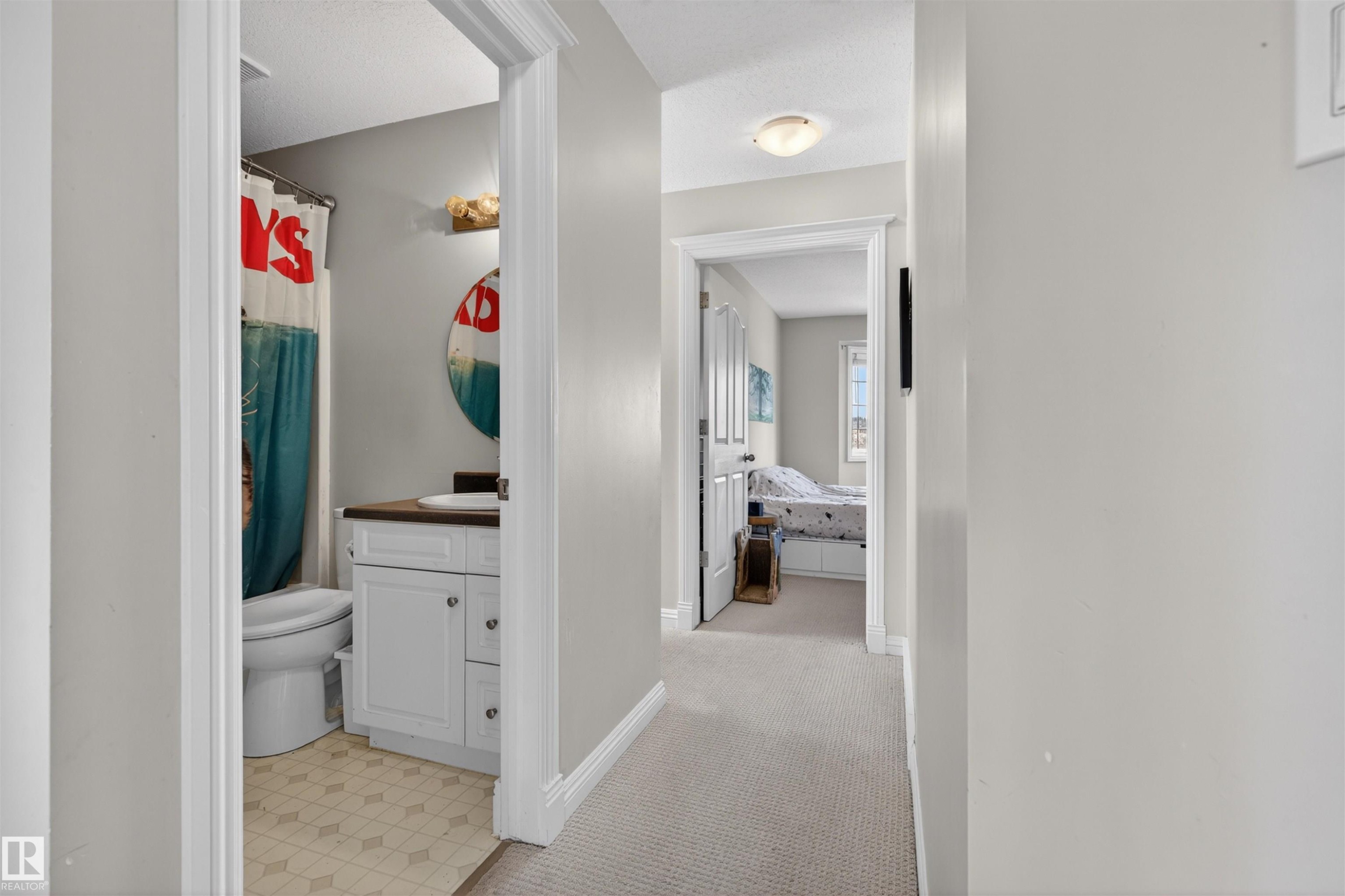 Hallway featuring light-colored carpet flooring and doors providing entry to separate areas of the property - 2 Sturgeon Road, St. Albert, AB - Indoor