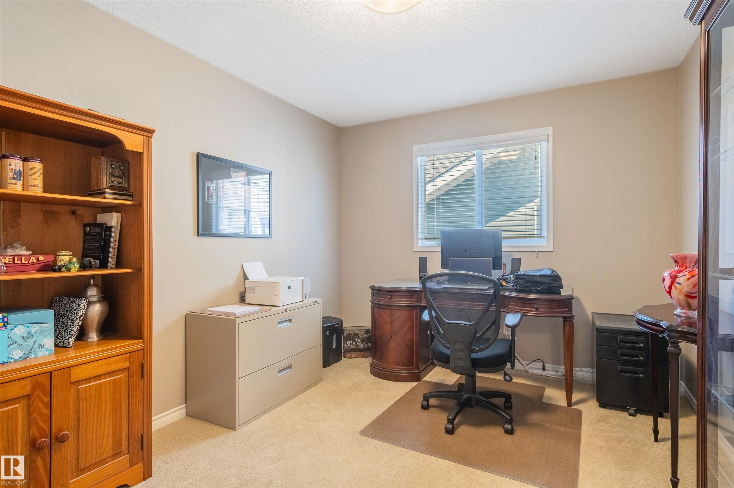 Carpeted room featuring a white-framed window with blinds, neutral painted walls, and an overhead light fixture - 121 Ellington Crescent, St. Albert, AB - Indoor Photo Showing Office