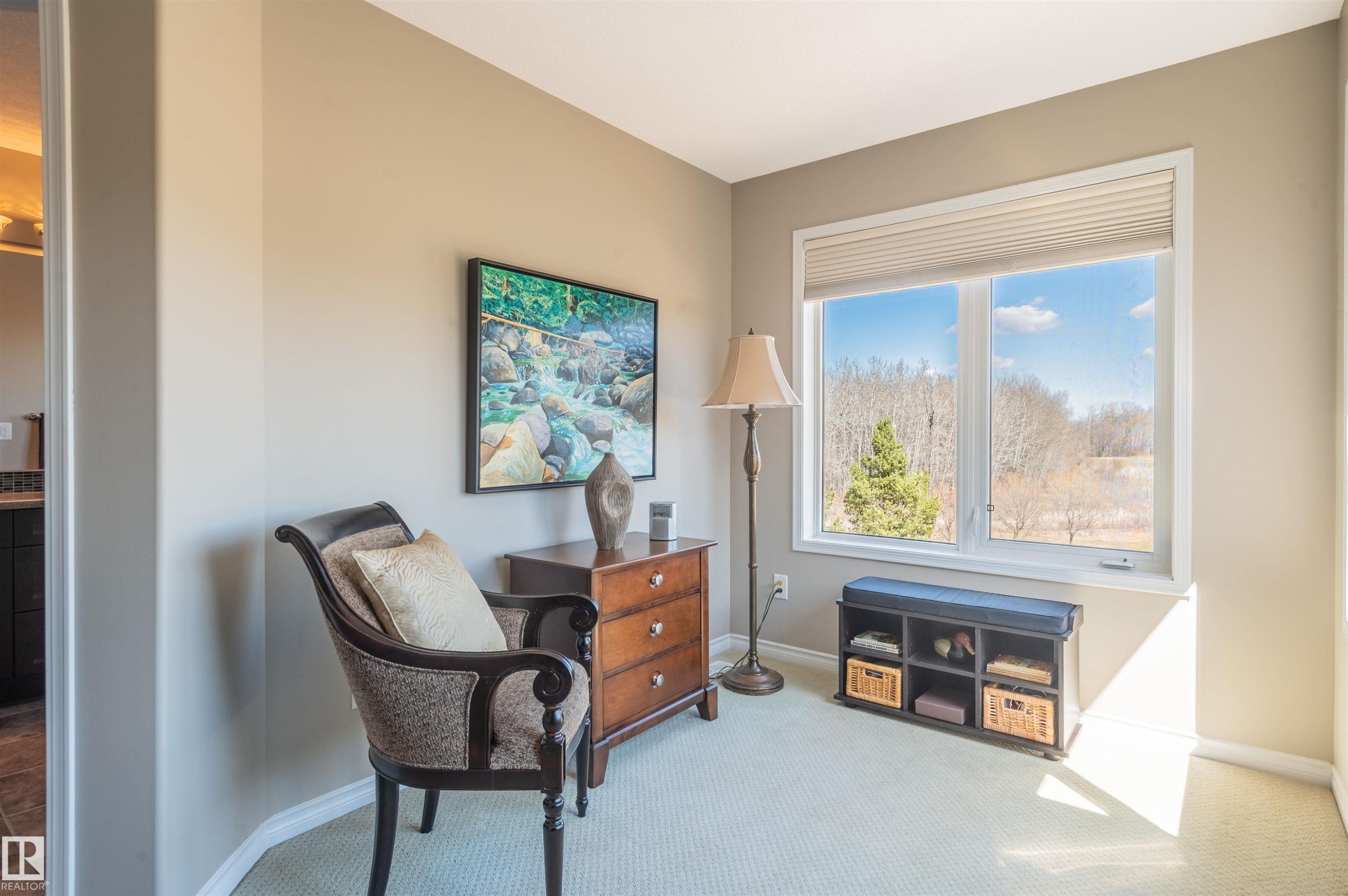 Bright room featuring a large window with roller shades, light-toned wall paint, and light-colored carpeting - 121 Ellington Crescent, St. Albert, AB - Indoor