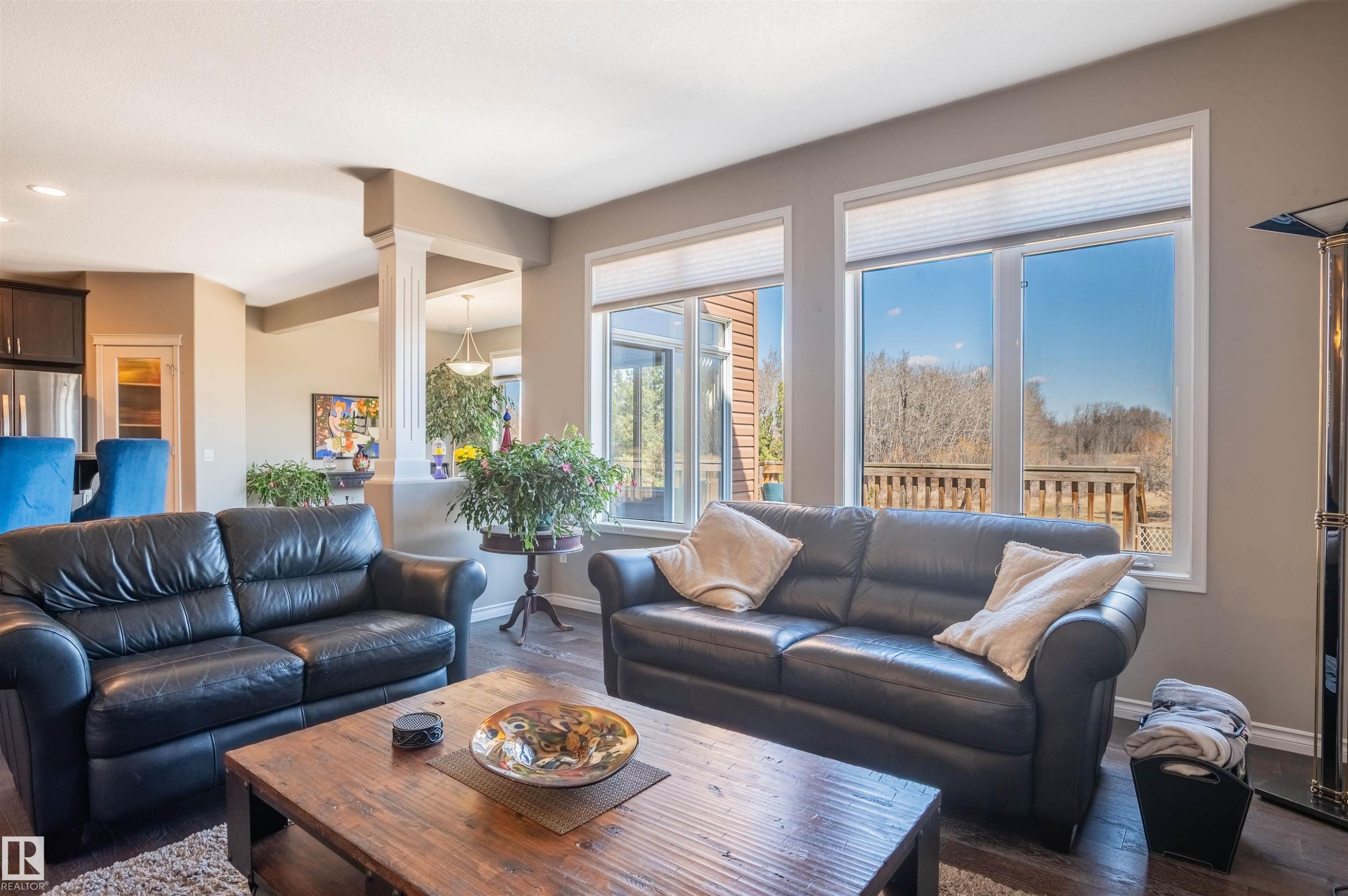Living area featuring dark wood-finish flooring, light grey painted walls, and ample natural light from multiple windows - 121 Ellington Crescent, St. Albert, AB - Indoor Photo Showing Living Room