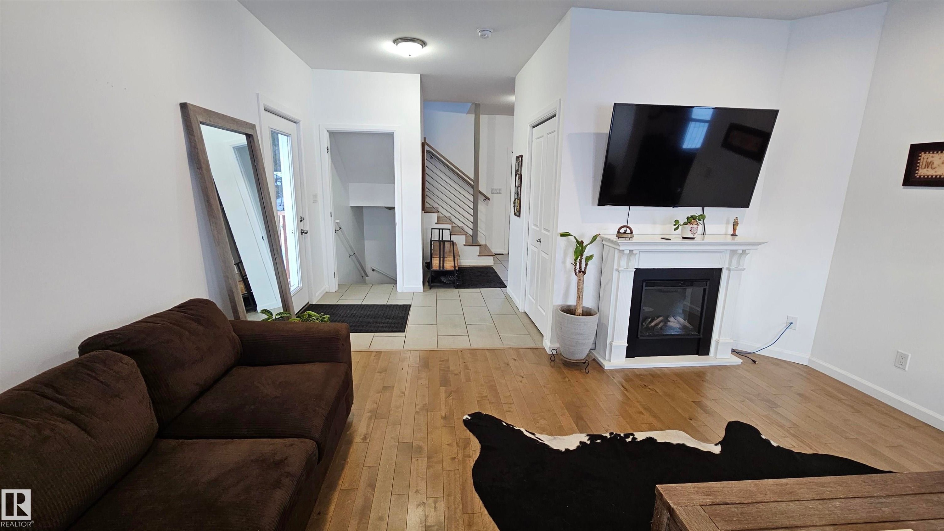 Looking towards the basement stairs and front entrance - 58513 Range Road 231, Rural Thorhild County, AB - Indoor Photo Showing Living Room With Fireplace