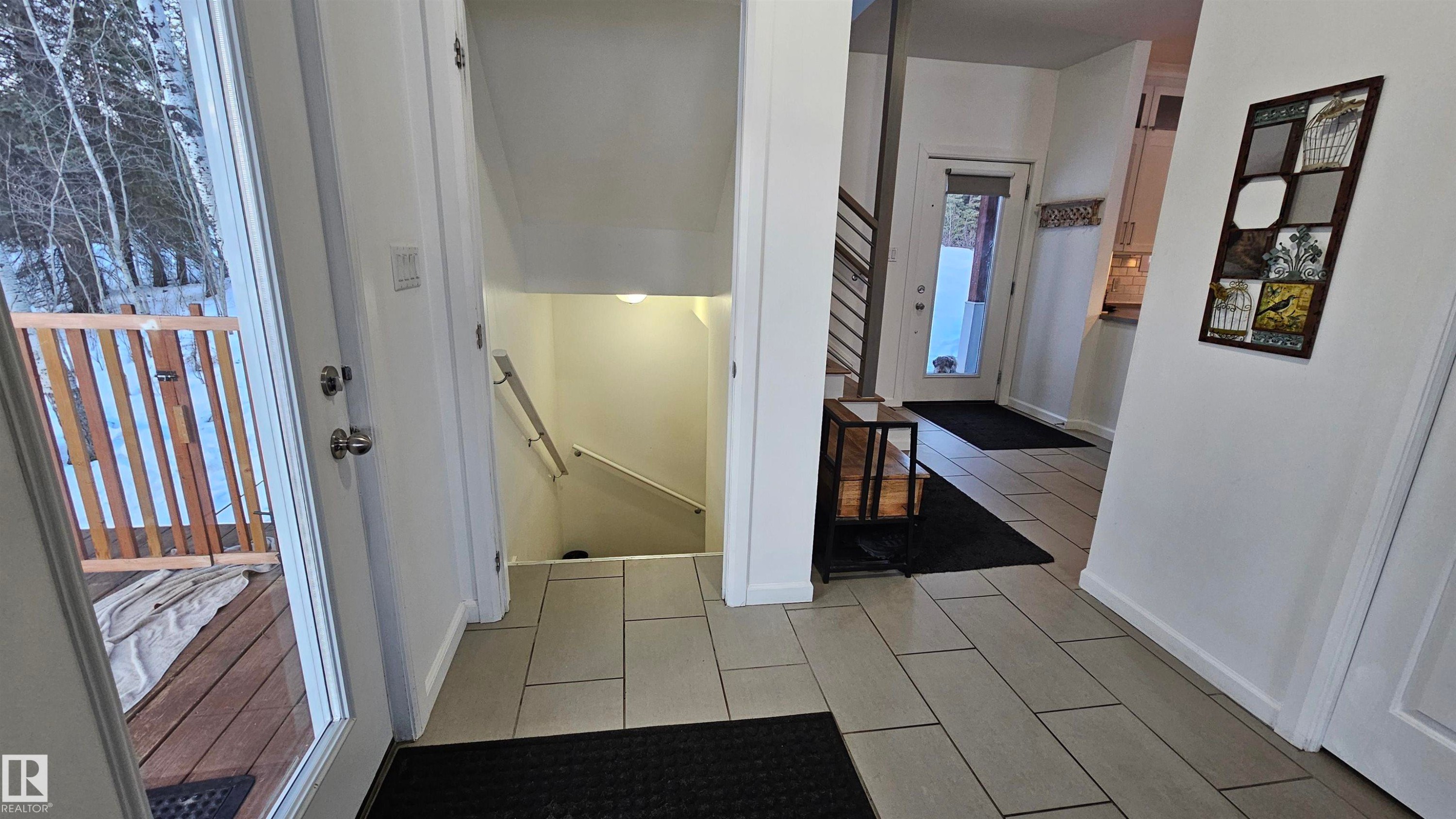 main floor looking toward basement stairs, door to wrap around deck on the left and front entrance/kitchen off to the right. - 58513 Range Road 231, Rural Thorhild County, AB - Indoor Photo Showing Other Room