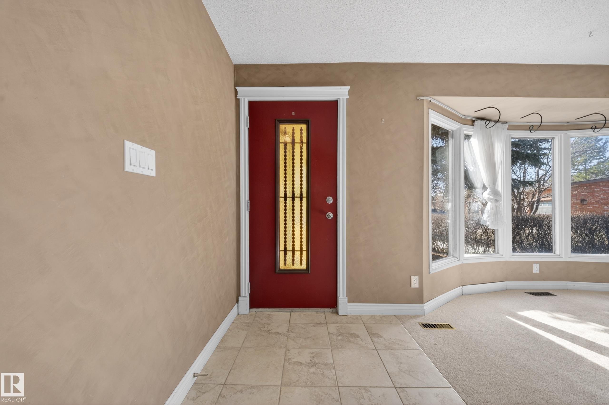 Entryway featuring a red door with decorative glass inserts, tile flooring, and a bay window - 1767 61 Street, Edmonton, AB - Indoor Photo Showing Other Room