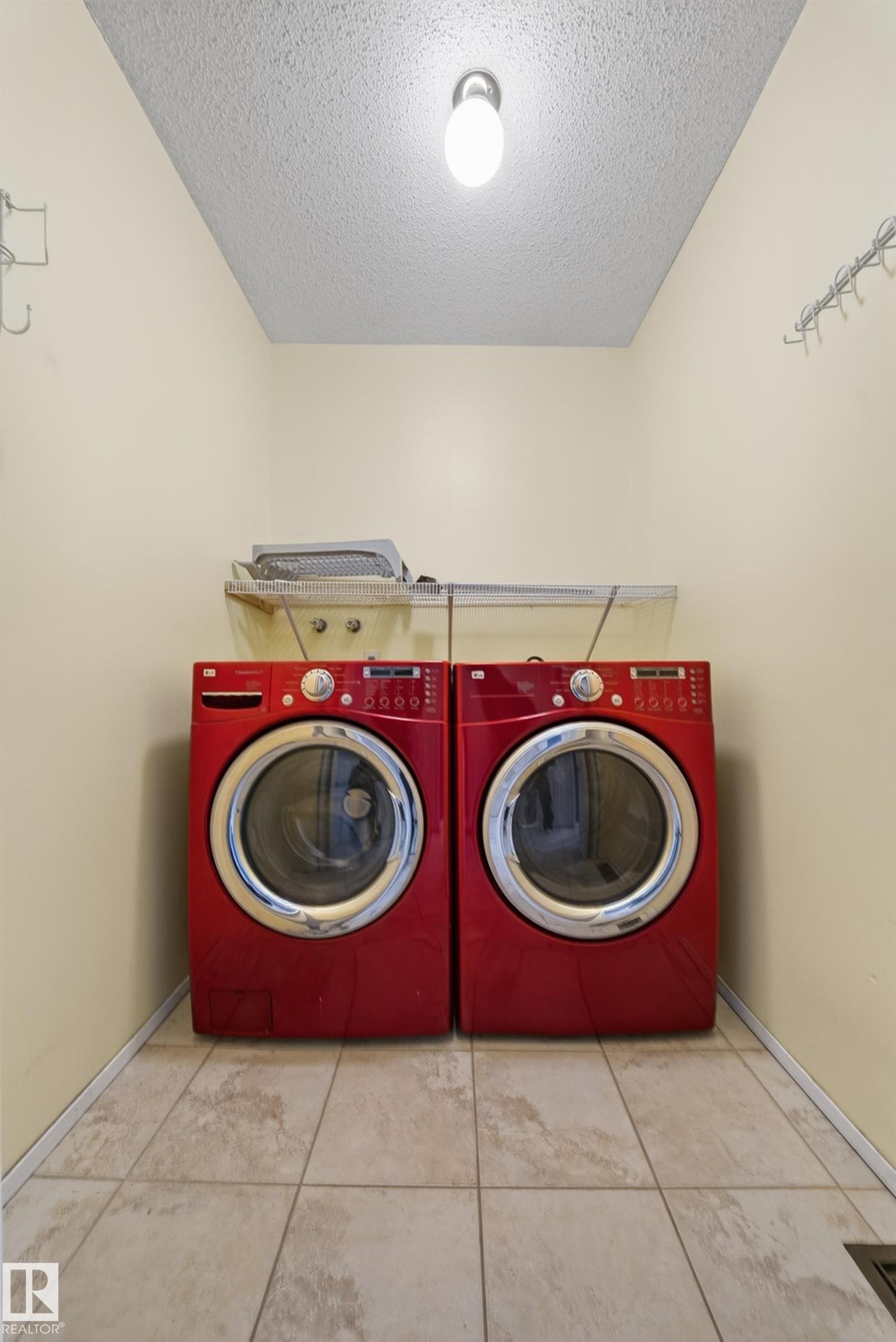 Dedicated laundry area featuring ceramic tile flooring, a wall-mounted utility shelf, and ceiling-mounted lighting - 1767 61 Street, Edmonton, AB - Indoor Photo Showing Laundry Room