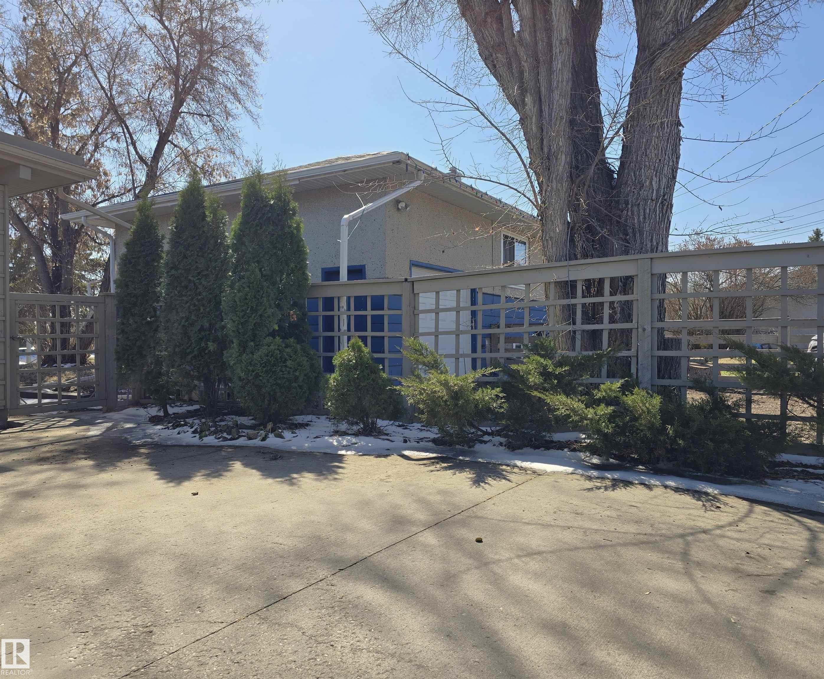 Concrete paving and a lattice fence delineate the property boundary - 9624 75 Street, Edmonton, AB - Outdoor
