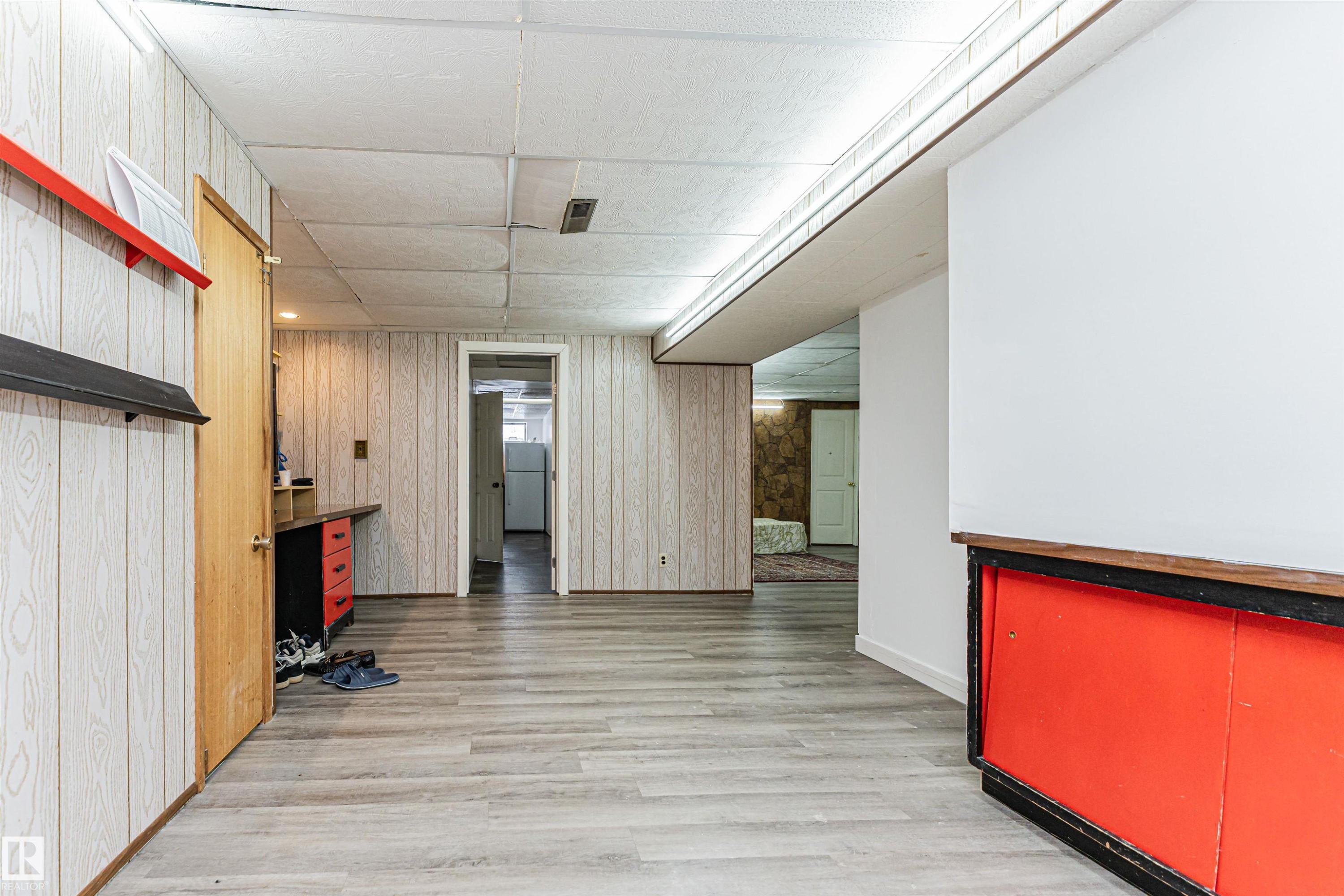 Versatile interior space featuring light wood-look flooring and white paneled walls - 10412 39 Avenue, Edmonton, AB - Indoor Photo Showing Other Room