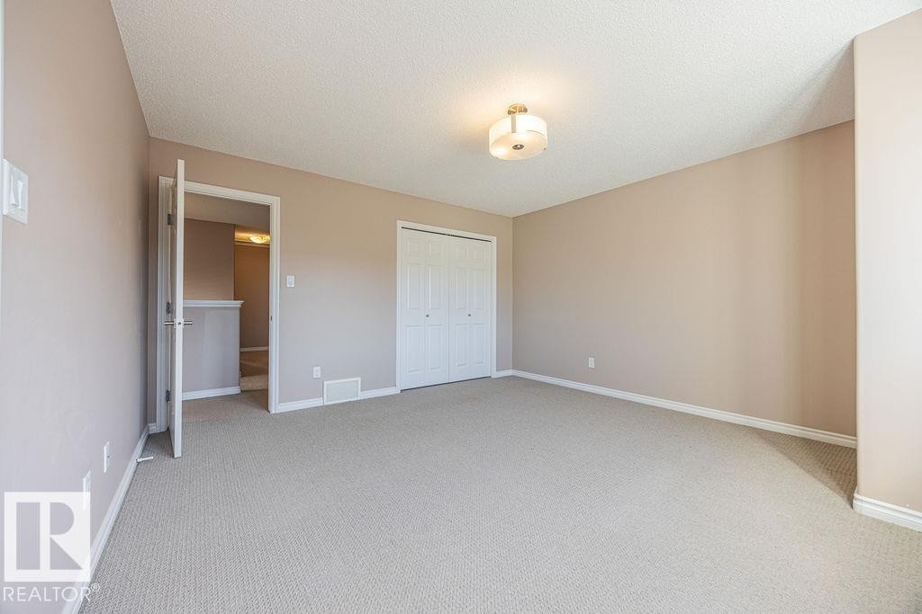 Carpeted room with neutral wall tones and a textured ceiling - 14 9350 211 Street, Edmonton, AB - Indoor Photo Showing Other Room