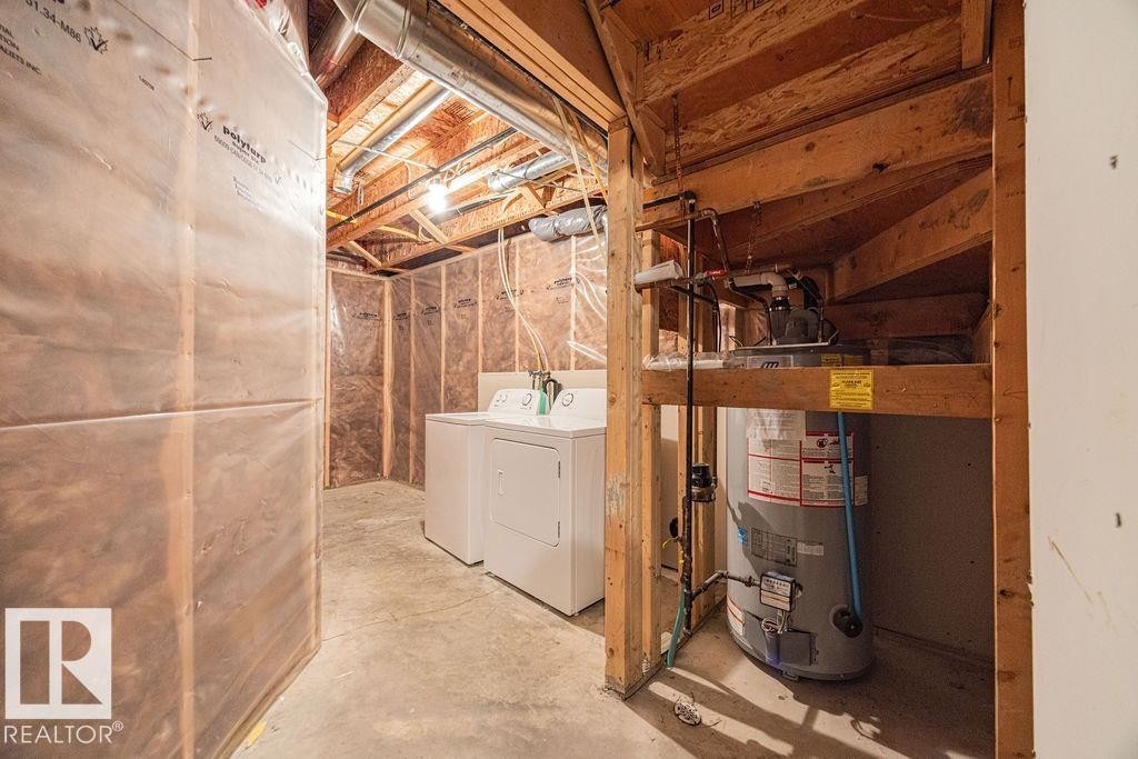 Utility area featuring a water heater, exposed wood framing, and concrete flooring - 14 9350 211 Street, Edmonton, AB - Indoor Photo Showing Laundry Room