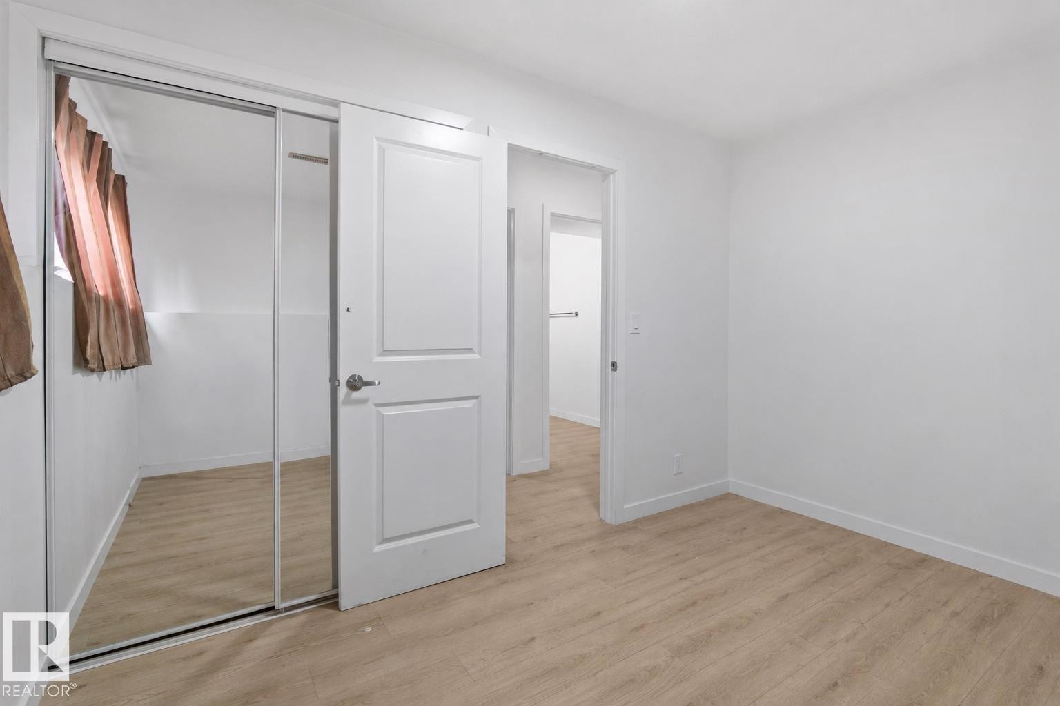 Bedroom featuring light wood-finish flooring, white painted walls, and white baseboards - 1566 Lakewood Road Nw, Edmonton, AB - Indoor Photo Showing Other Room