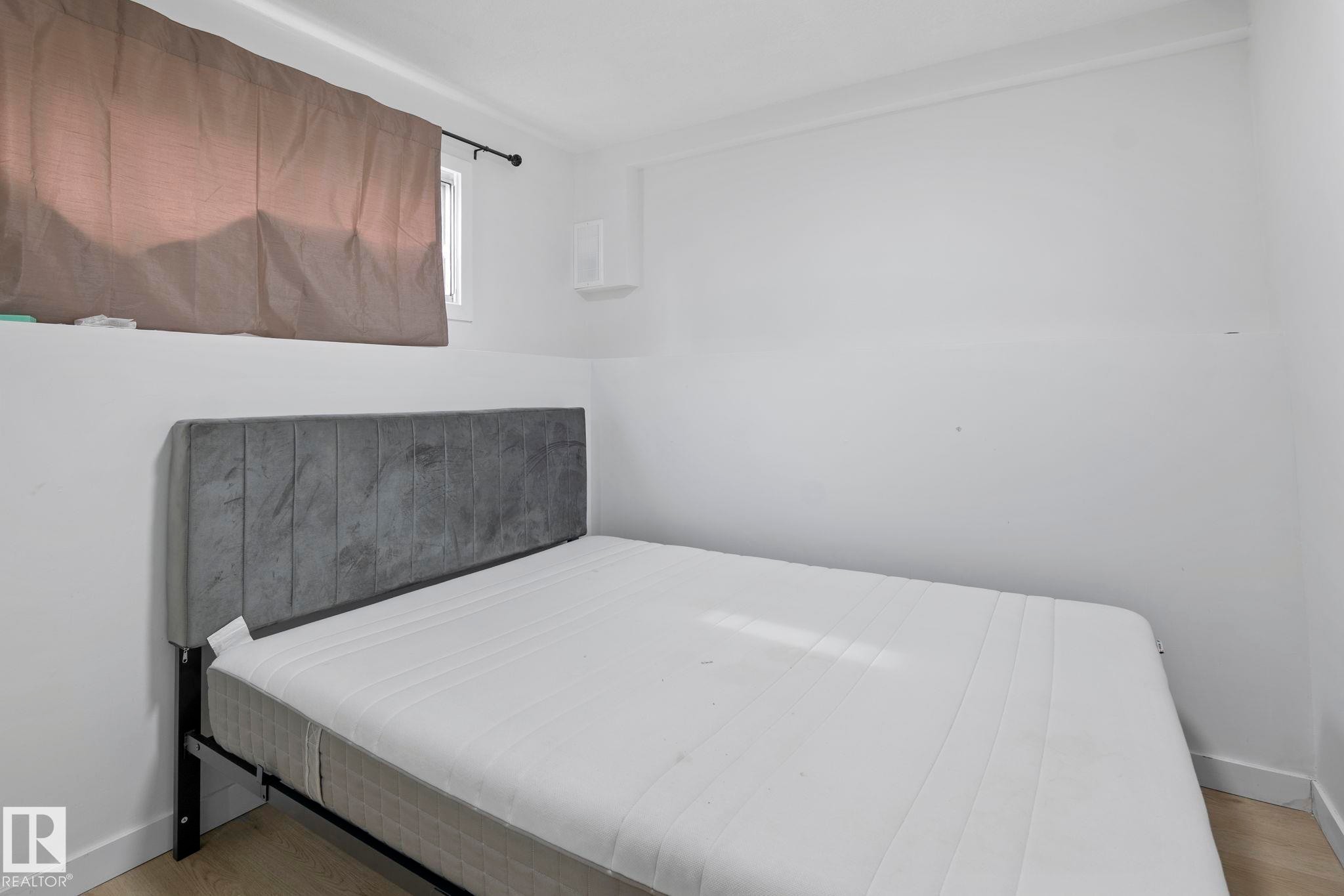 Bedroom featuring light wood-finish flooring, white walls, and white baseboards - 1566 Lakewood Road Nw, Edmonton, AB - Indoor Photo Showing Bedroom