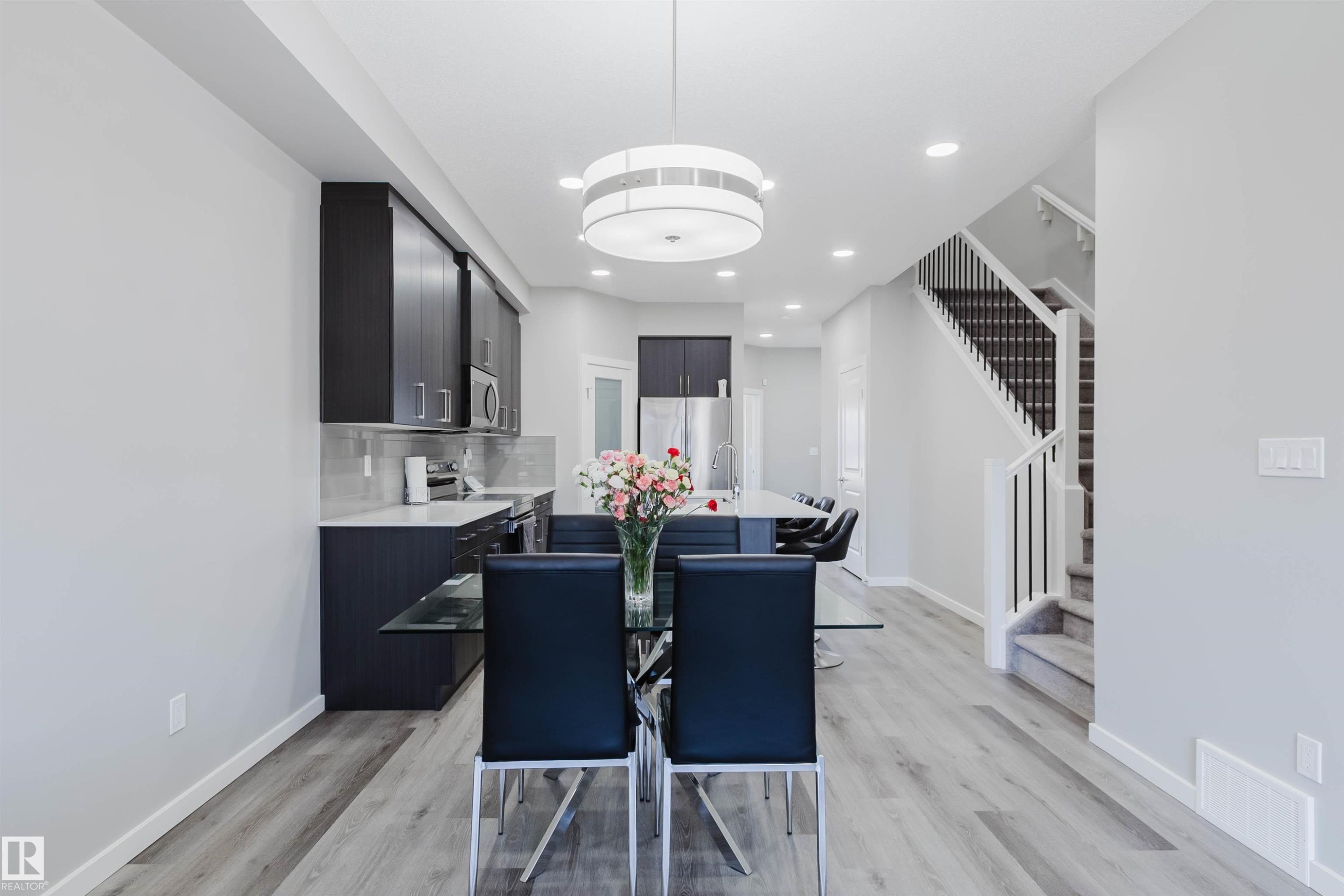 Open-concept living area featuring light wood-finish flooring, recessed lighting, and a modern chandelier - 343 Edgemont Drive, Edmonton, AB - Indoor