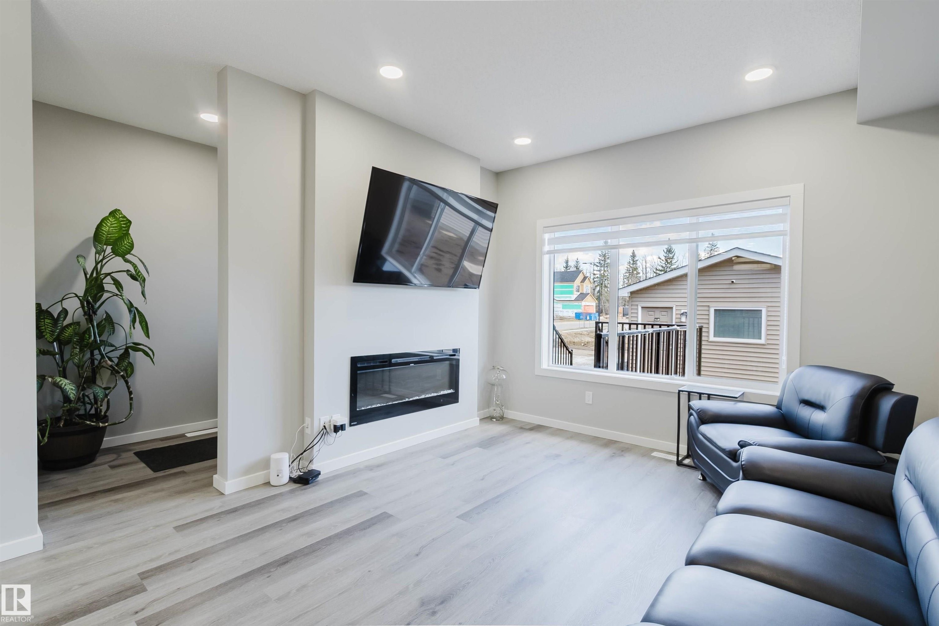 Living area featuring light gray walls, recessed lighting, and wood-finish flooring - 343 Edgemont Drive, Edmonton, AB - Indoor Photo Showing Living Room With Fireplace