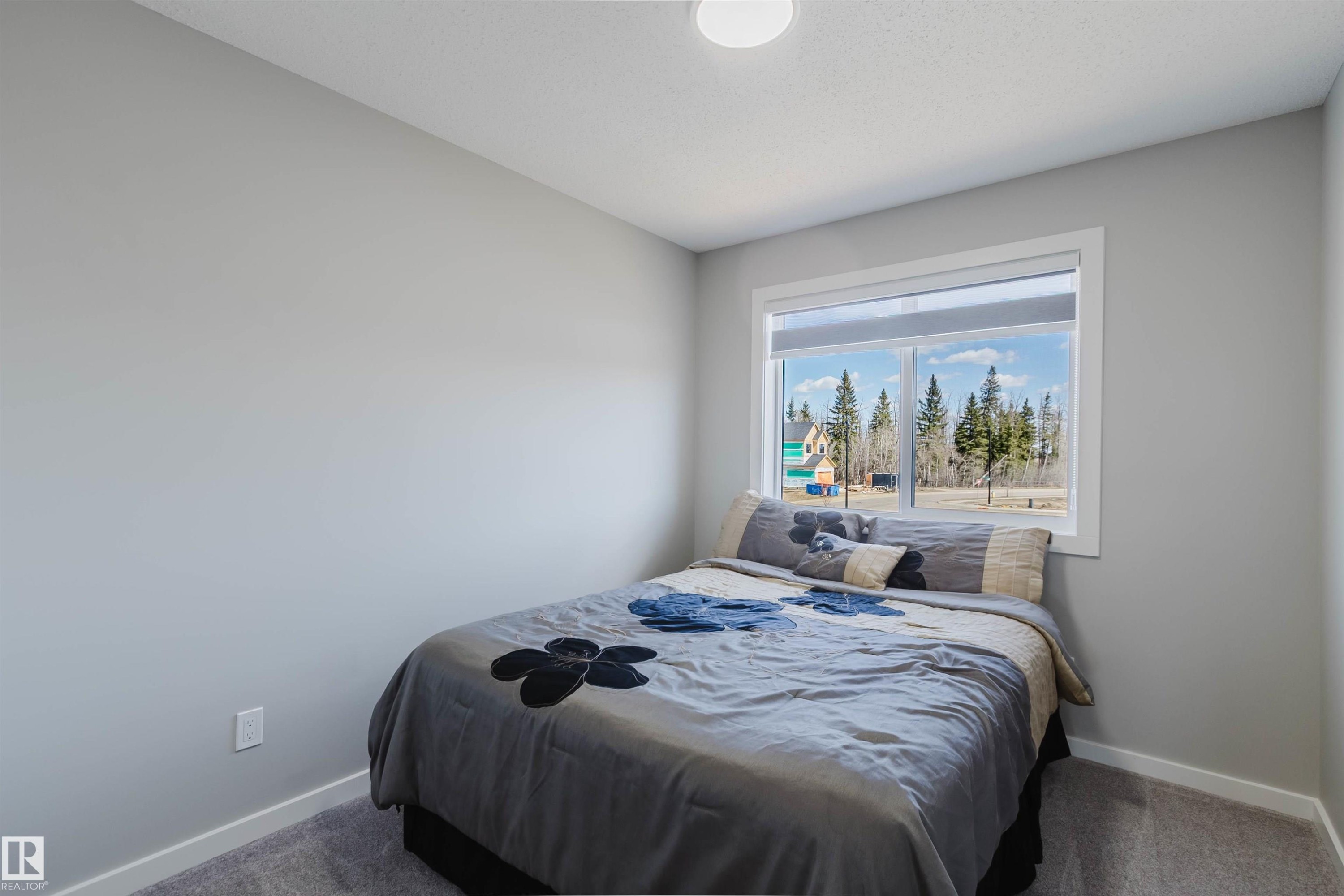 Bedroom featuring a large window, light gray wall paint, white baseboards, and gray carpeting - 343 Edgemont Drive, Edmonton, AB - Indoor Photo Showing Bedroom