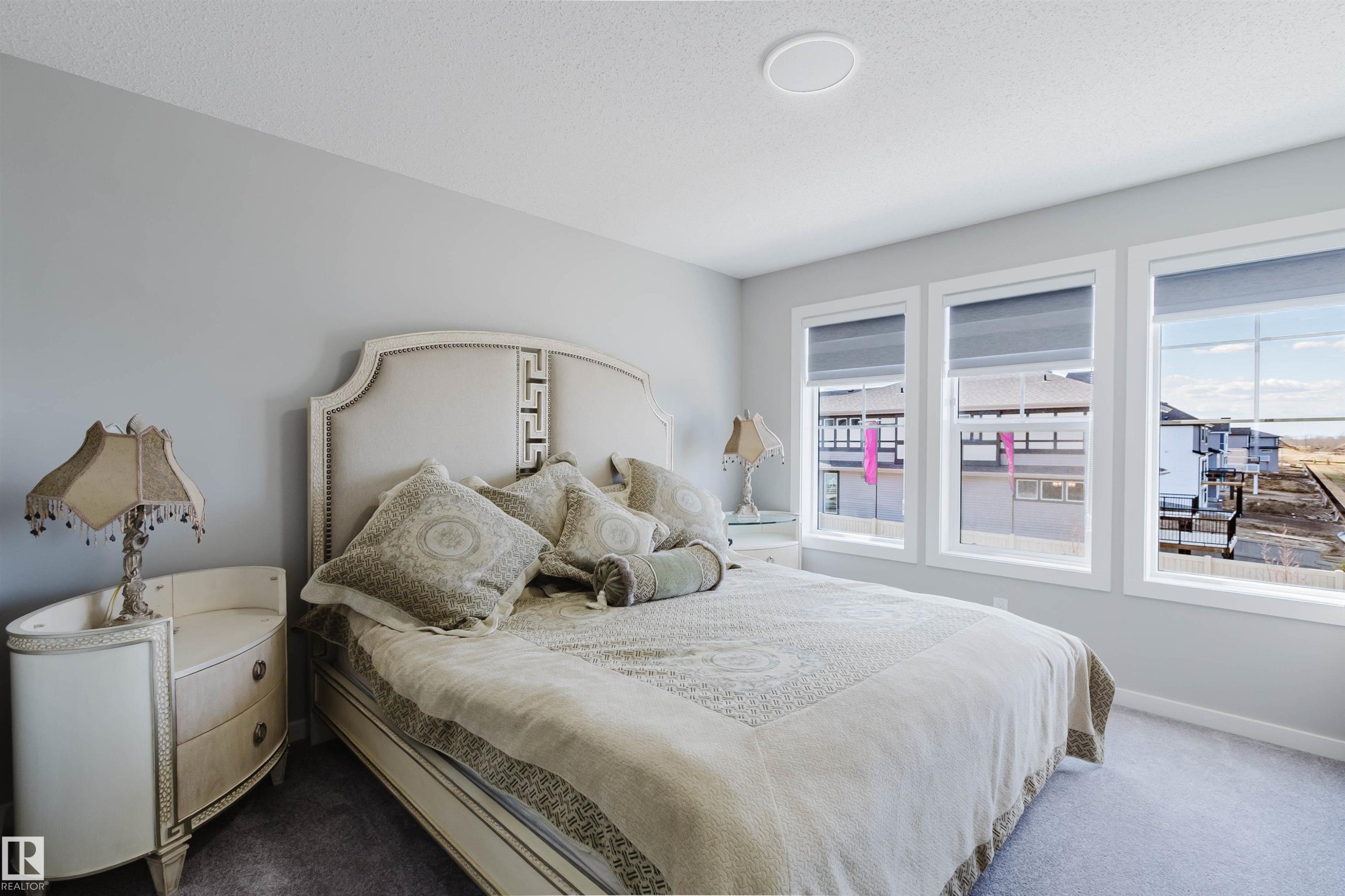 Bedroom featuring light gray walls, plush carpet flooring, three large windows with white trim, and a ceiling-mounted light fixture - 343 Edgemont Drive, Edmonton, AB - Indoor Photo Showing Bedroom