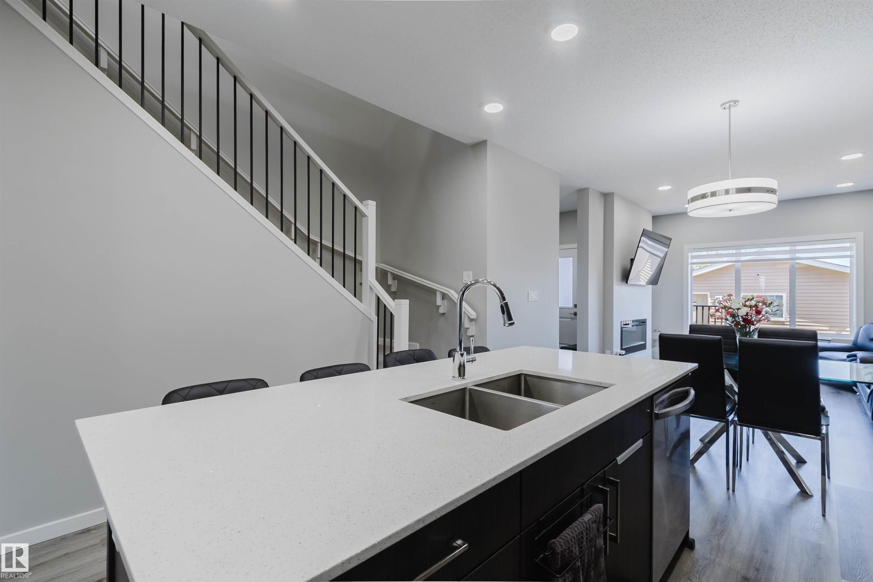 Kitchen island featuring a double basin stainless steel sink with a gooseneck faucet - 343 Edgemont Drive, Edmonton, AB - Indoor Photo Showing Kitchen With Double Sink