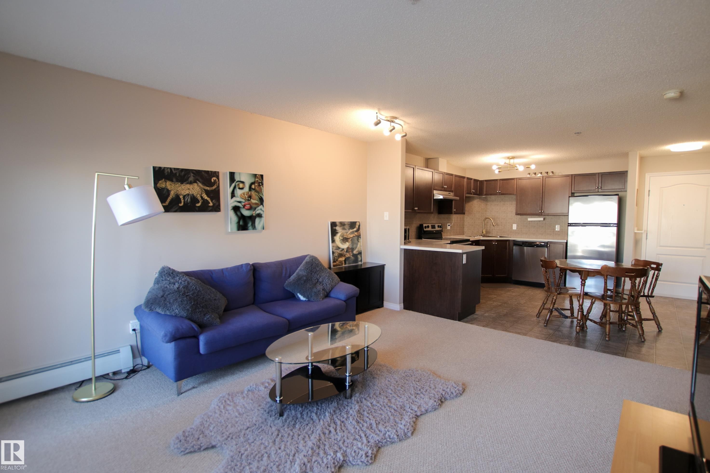 Open-concept living space with light neutral wall paint and a light-colored carpeted floor - 7206 7327 South Terwillegar Drive, Edmonton, AB - Indoor Photo Showing Living Room