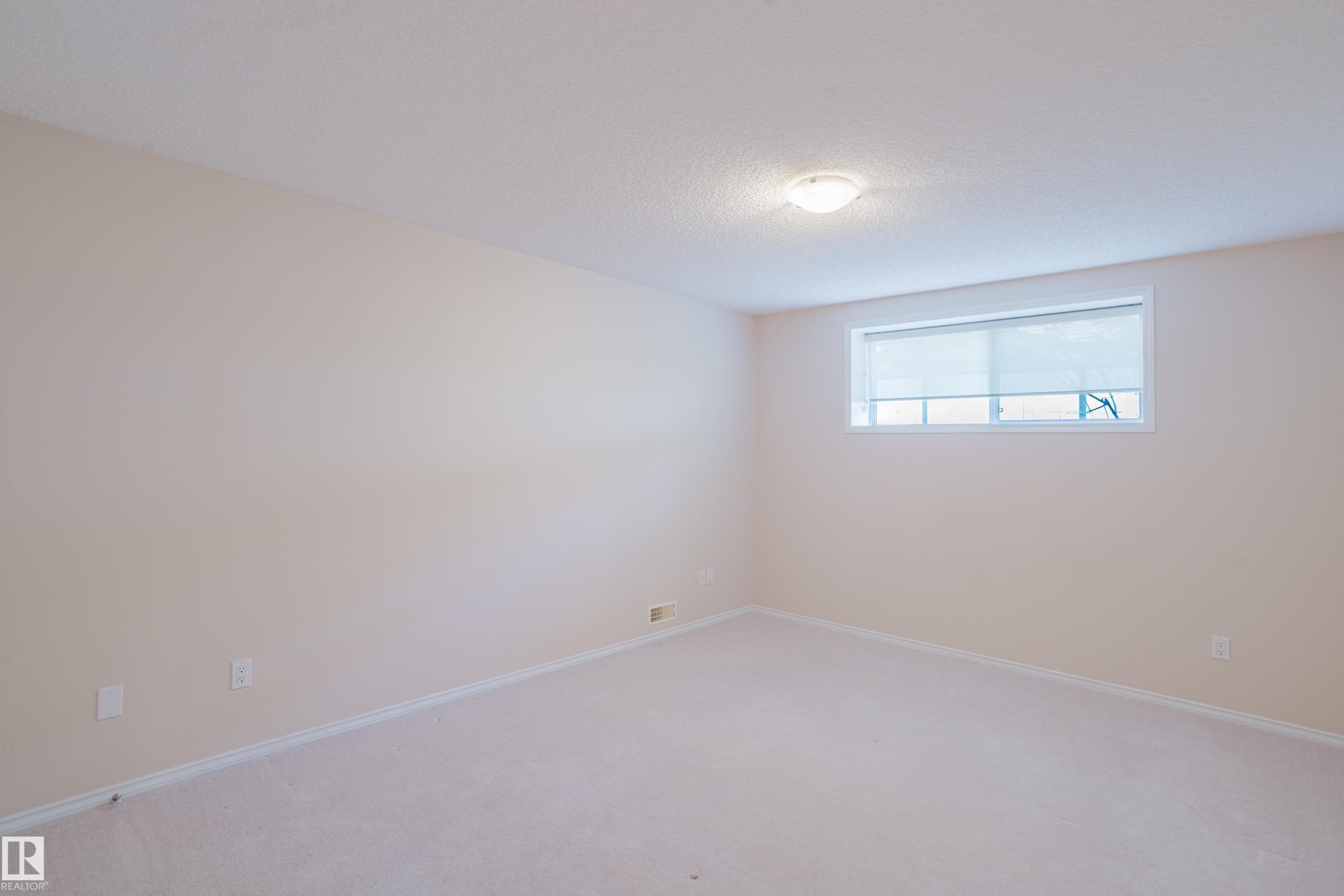 Spacious room with light-colored walls and wall-to-wall carpeting - 9 102 Bridgeport Crossing, Leduc, AB - Indoor Photo Showing Other Room