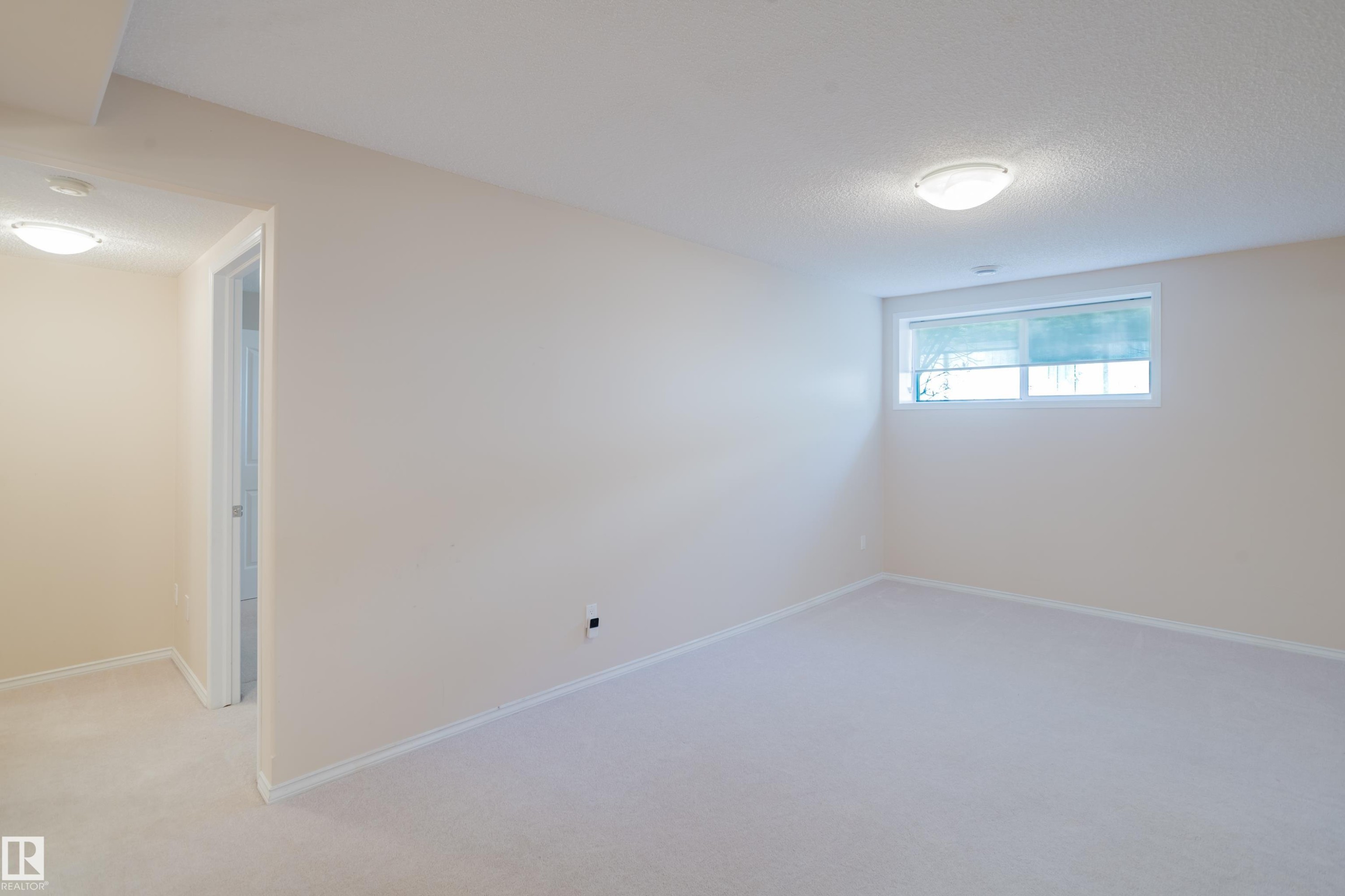 Carpeted room with neutral wall tones and white baseboards - 9 102 Bridgeport Crossing, Leduc, AB - Indoor Photo Showing Other Room