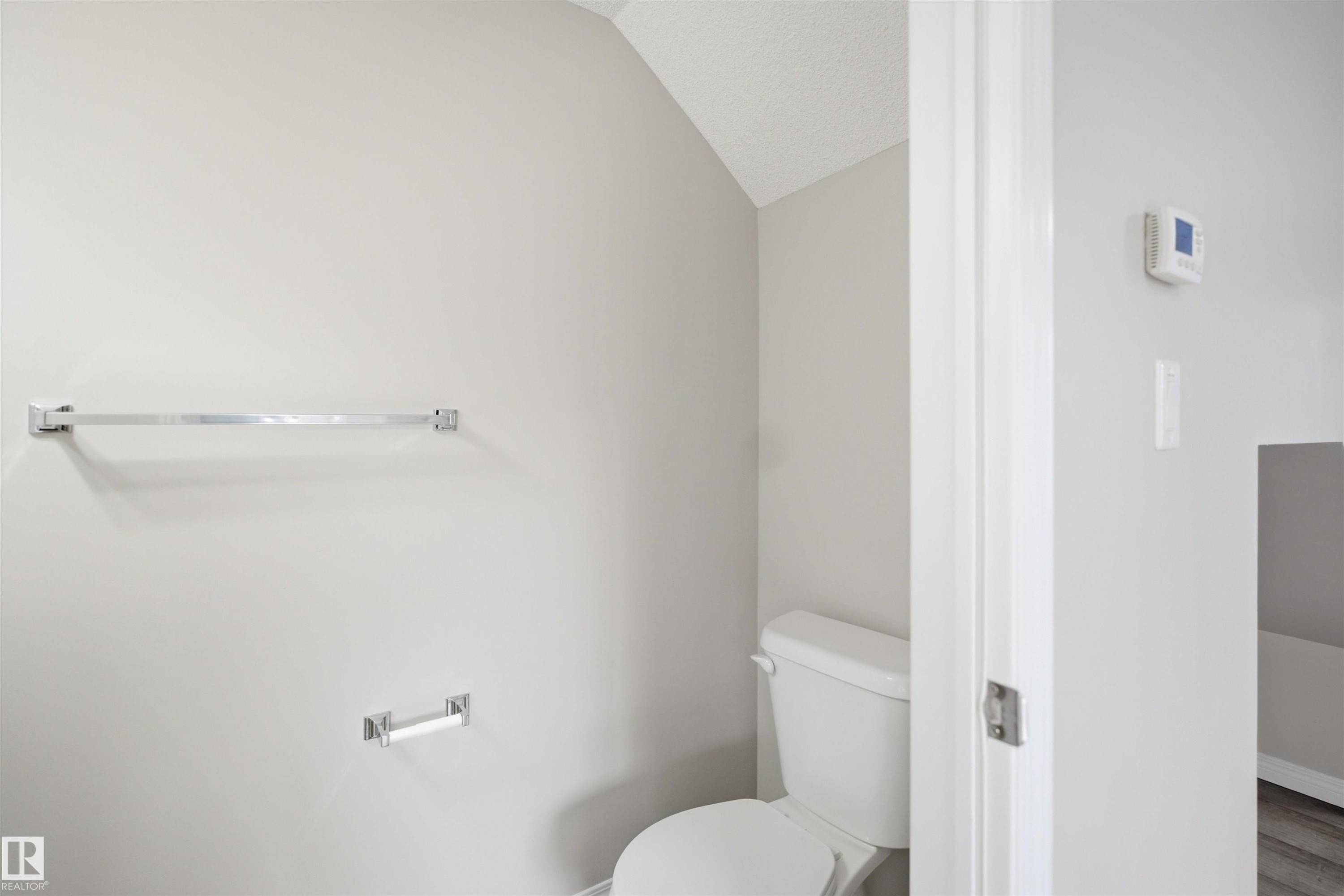 Bathroom featuring a white toilet, light gray walls, and textured ceiling - 33 7385 Edgemont Way Nw, Edmonton, AB - Indoor Photo Showing Bathroom