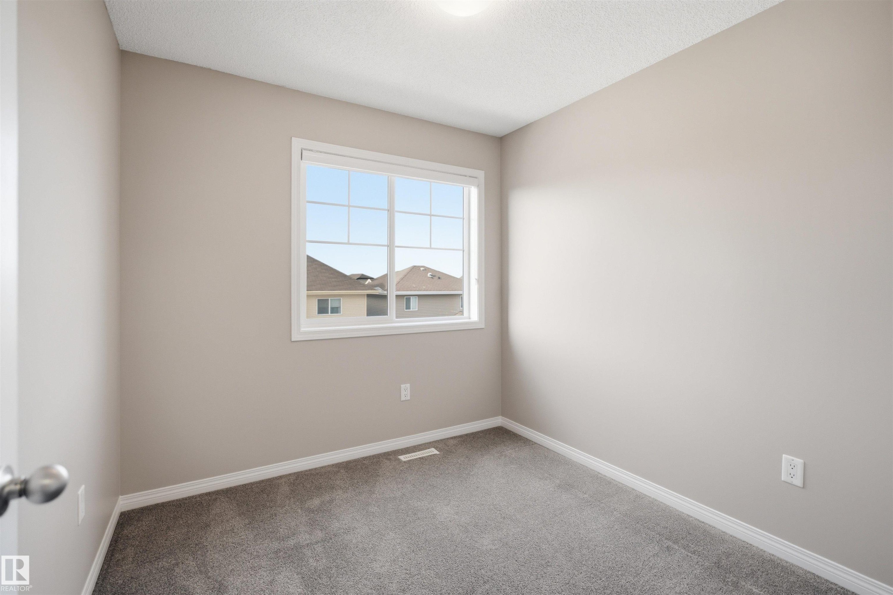 Room with light gray walls, gray carpeting, and white baseboards - 33 7385 Edgemont Way Nw, Edmonton, AB - Indoor Photo Showing Other Room