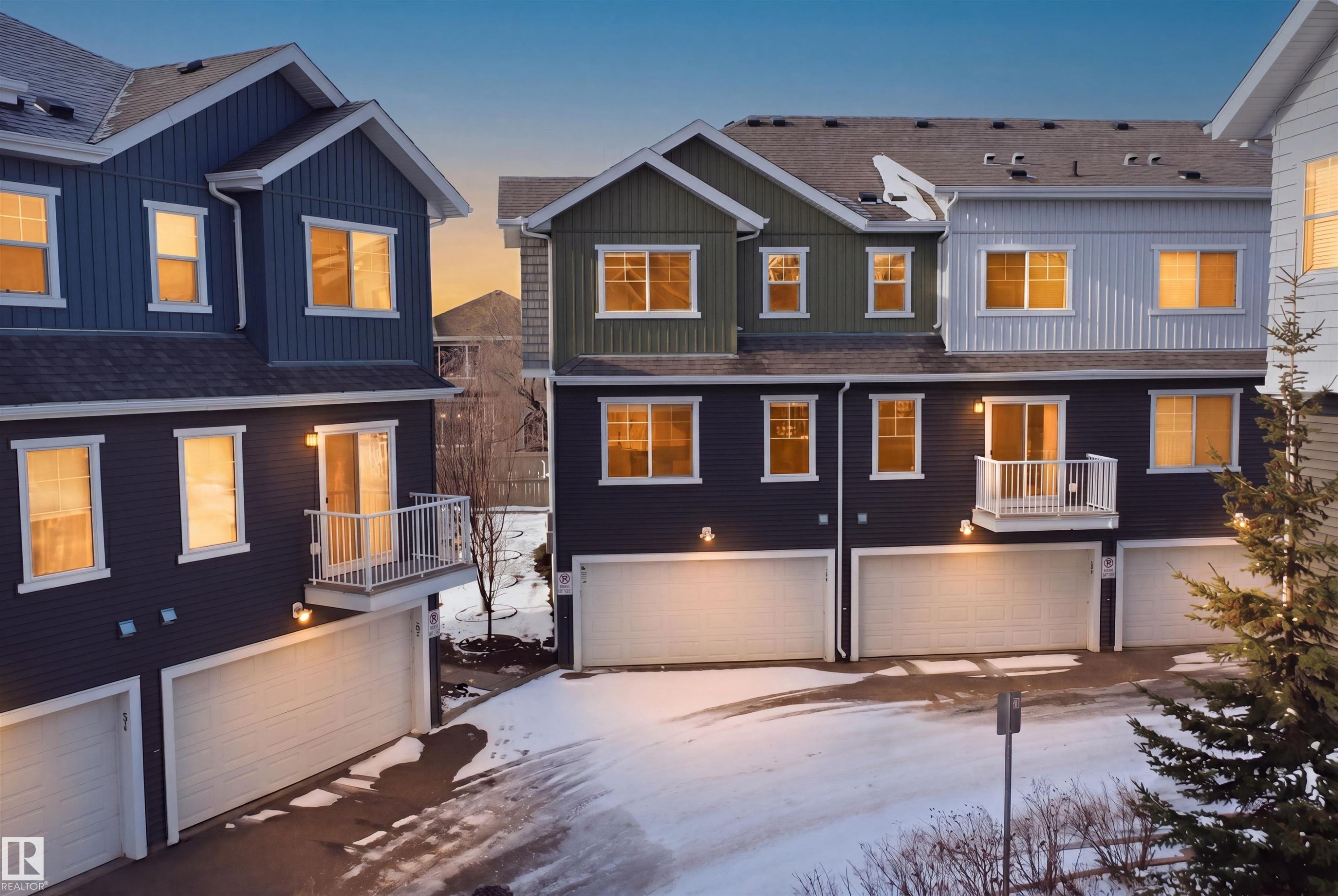 Modern multi-story townhomes featuring two-car garages, private balconies, and a combination of horizontal and vertical siding - 33 7385 Edgemont Way Nw, Edmonton, AB - Outdoor With Facade