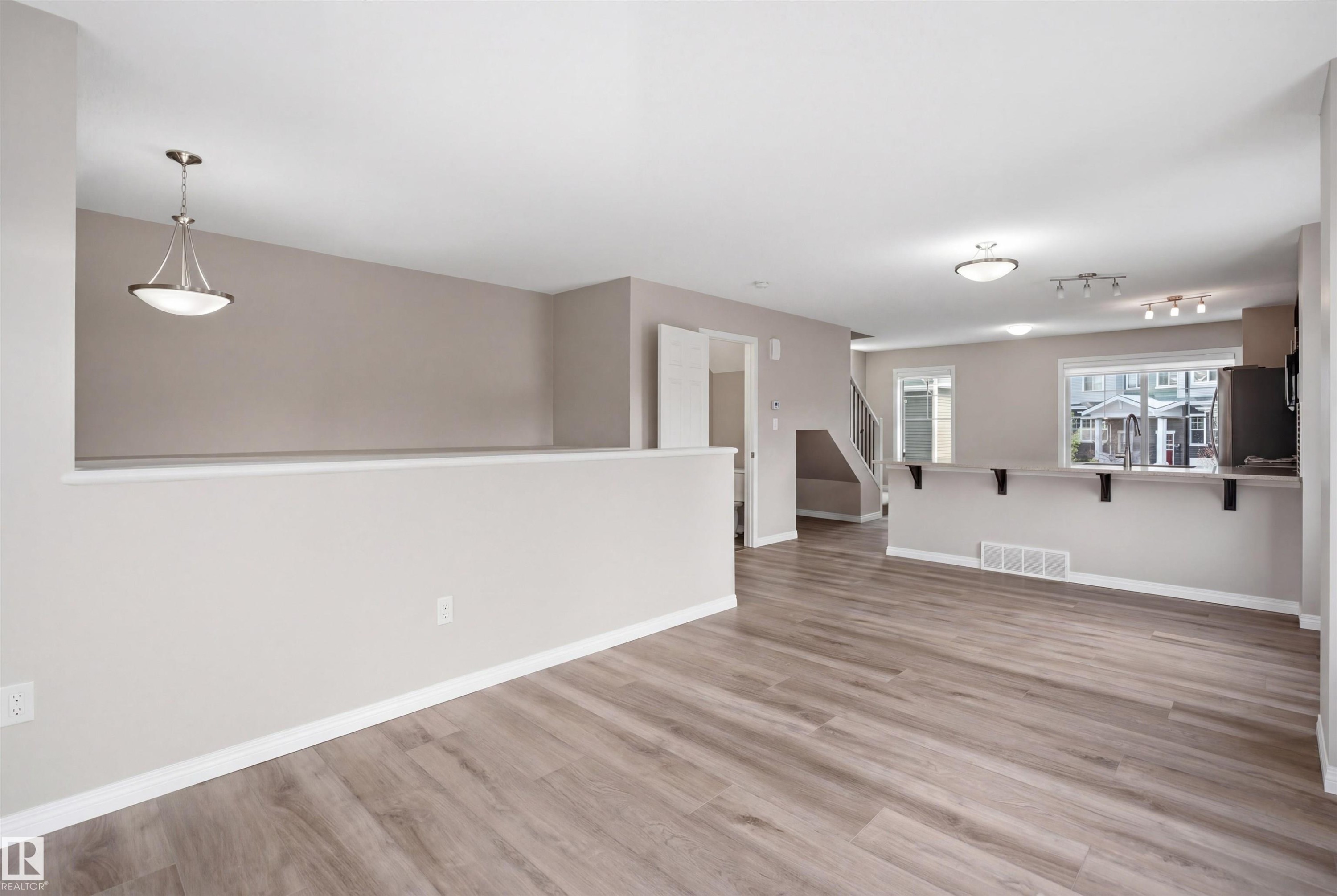 Open-concept living area featuring wood-finish flooring, neutral wall tones, and recessed lighting - 33 7385 Edgemont Way Nw, Edmonton, AB - Indoor Photo Showing Other Room